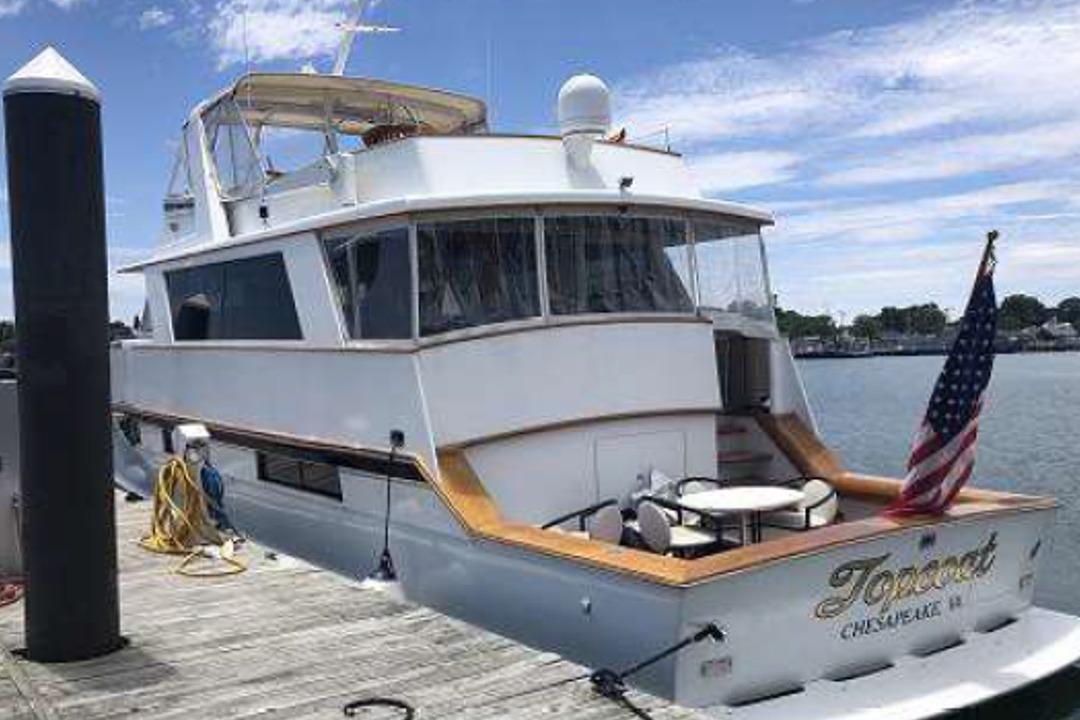 1974 Pacemaker Cockpit Motoryacht docked, featuring American flag and outdoor seating.