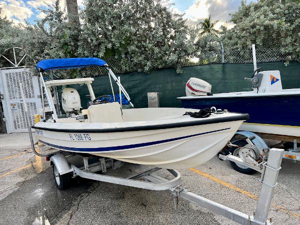 1986 Hoog Comet 14 boat on trailer with blue canopy.