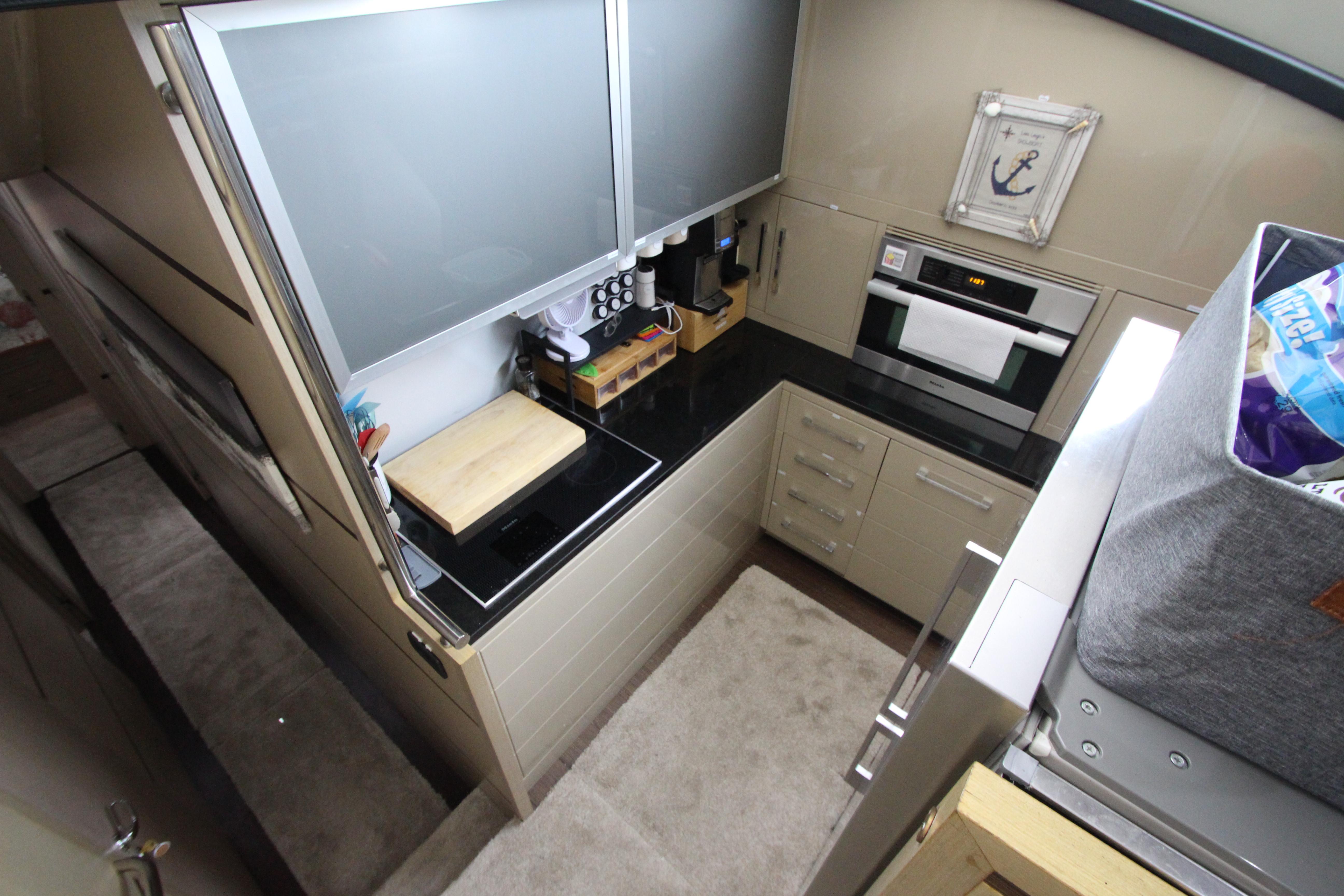 Modern kitchen in 2007 Uniesse 70 Sport yacht with sleek countertops and appliances.