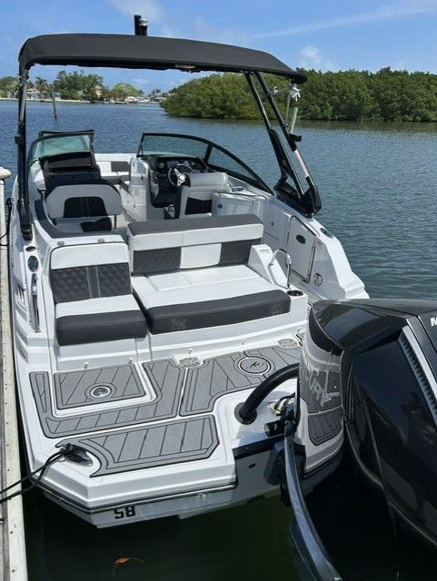 A modern motorboat docked at a pier in calm water, surrounded by mangroves.