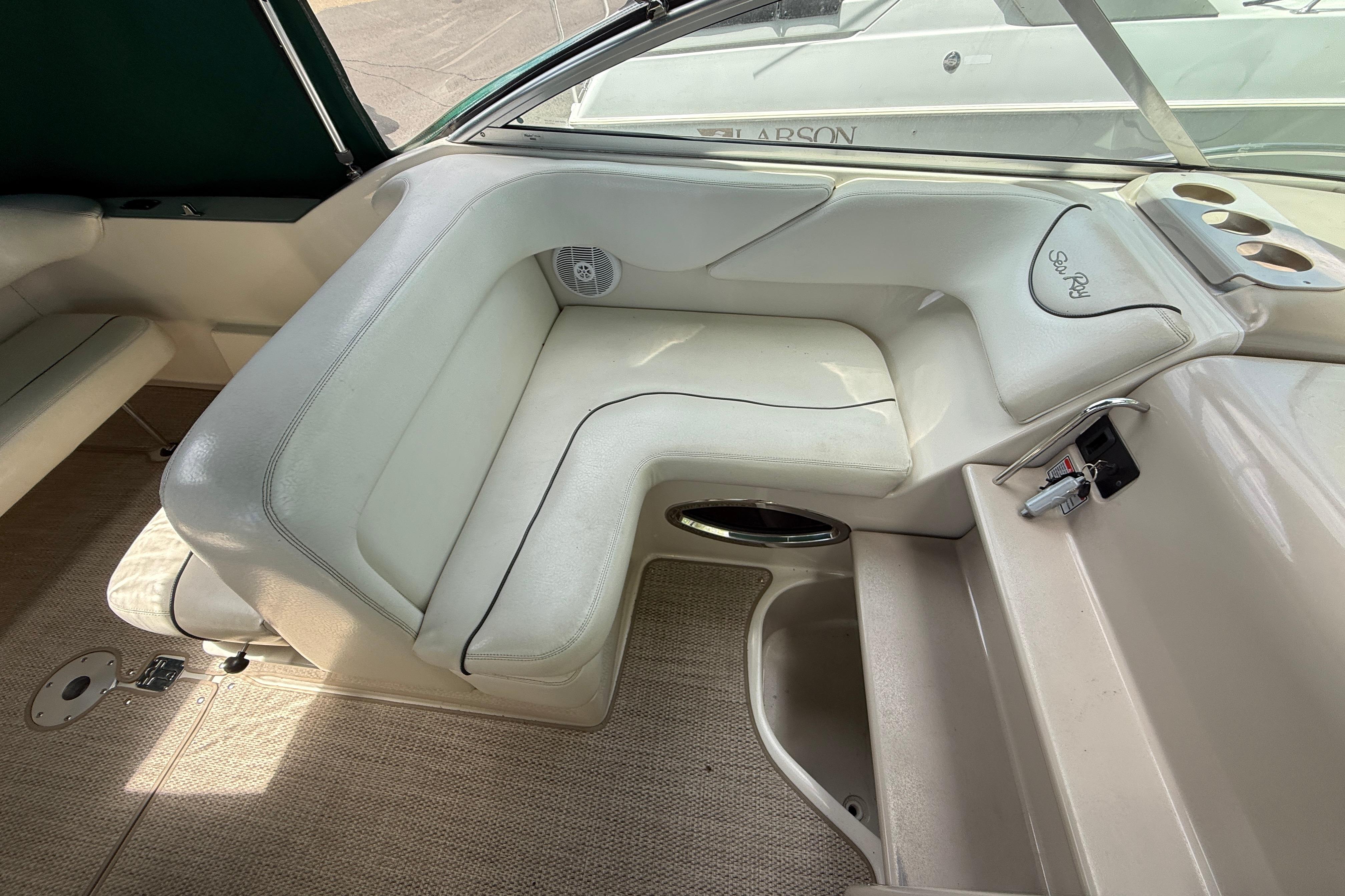 2004 Sea Ray 240 Sundancer interior with white seating and cup holders.