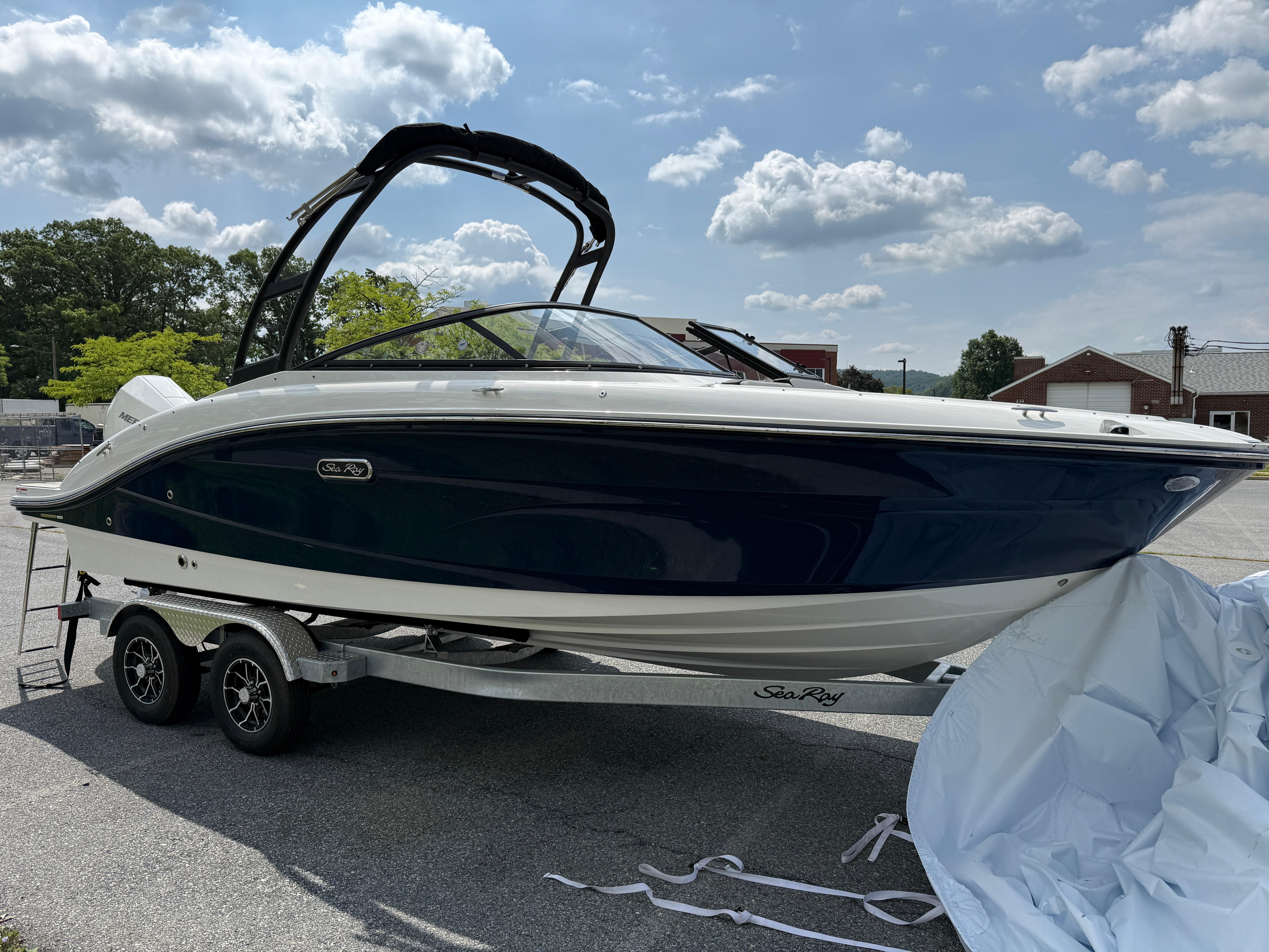 2026 Sea Ray SPX 210 Outboard boat on trailer under a partly cloudy sky.