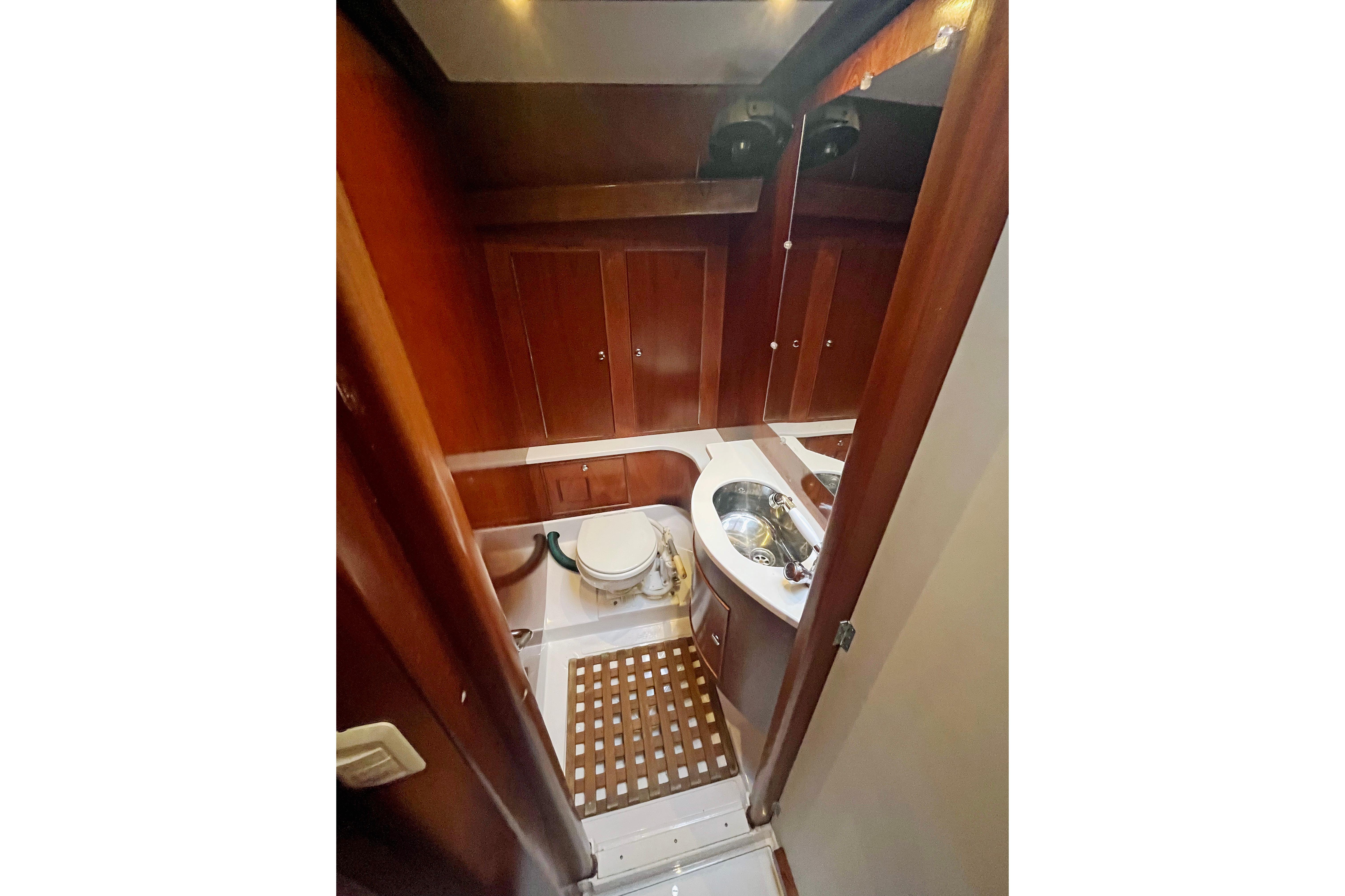 1979 Amel Mango yacht bathroom with wooden cabinets and compact sink.