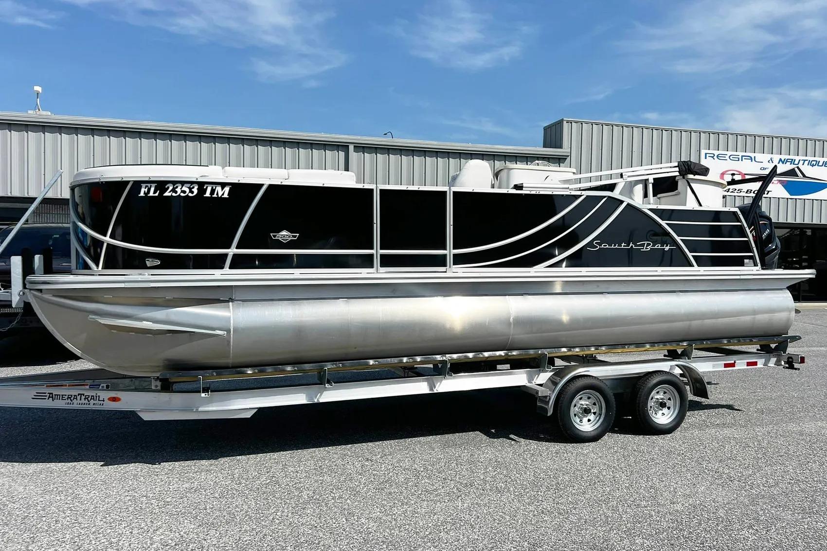 2023 South Bay 523 R pontoon boat on trailer, parked outdoors.