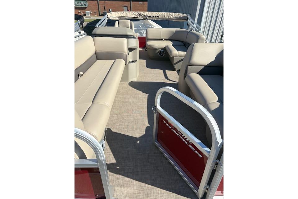 2025 Sun Tracker Party Barge 18 DLX interior with beige seating and open gate.