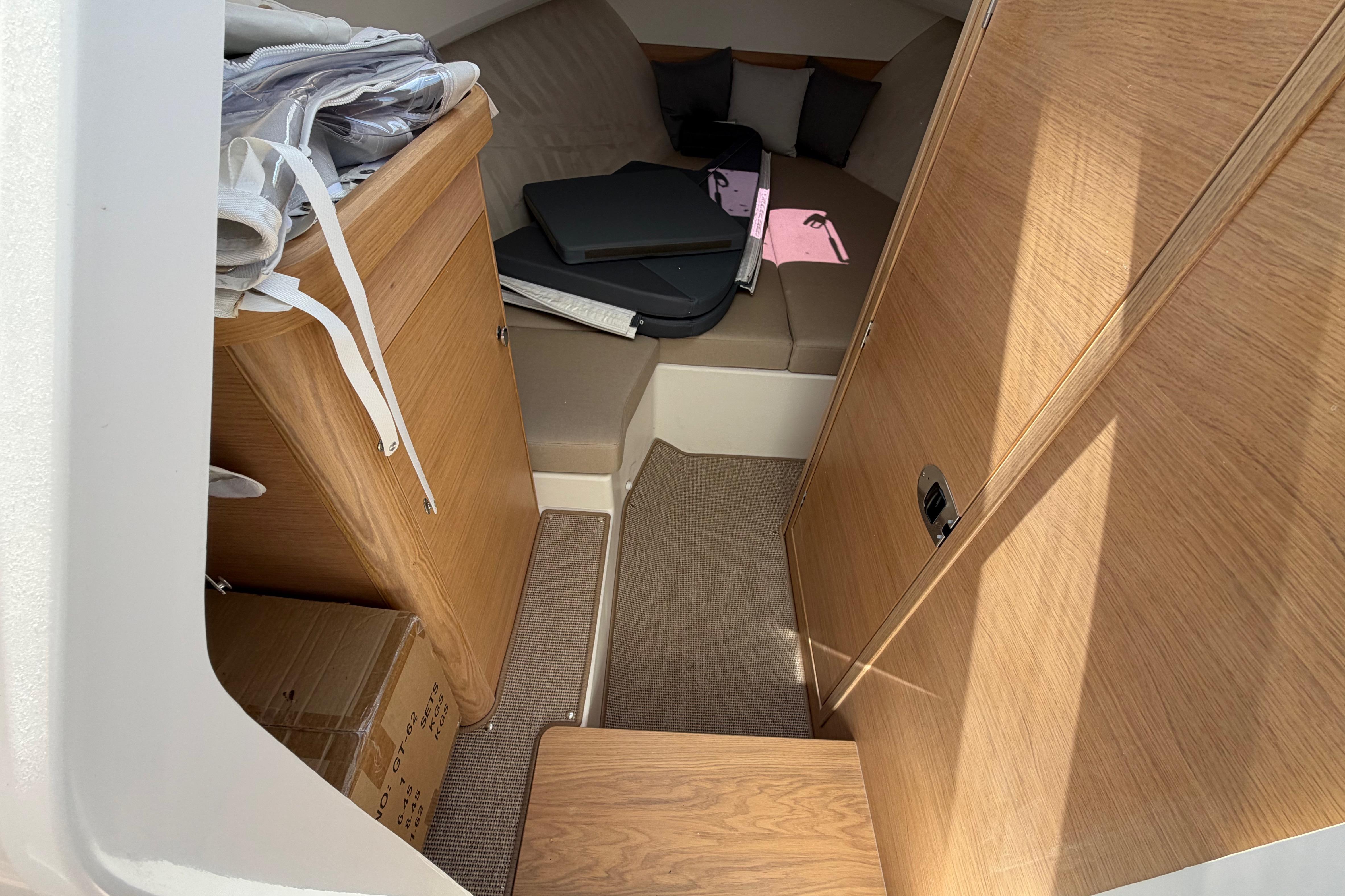 Interior cabin of 2025 Nimbus Weekender 9 boat with wooden finish and seating area.