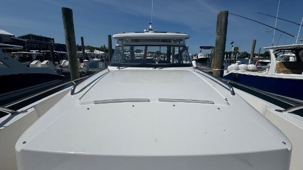 Nimbus T11 2025 boat docked at marina under clear blue sky.