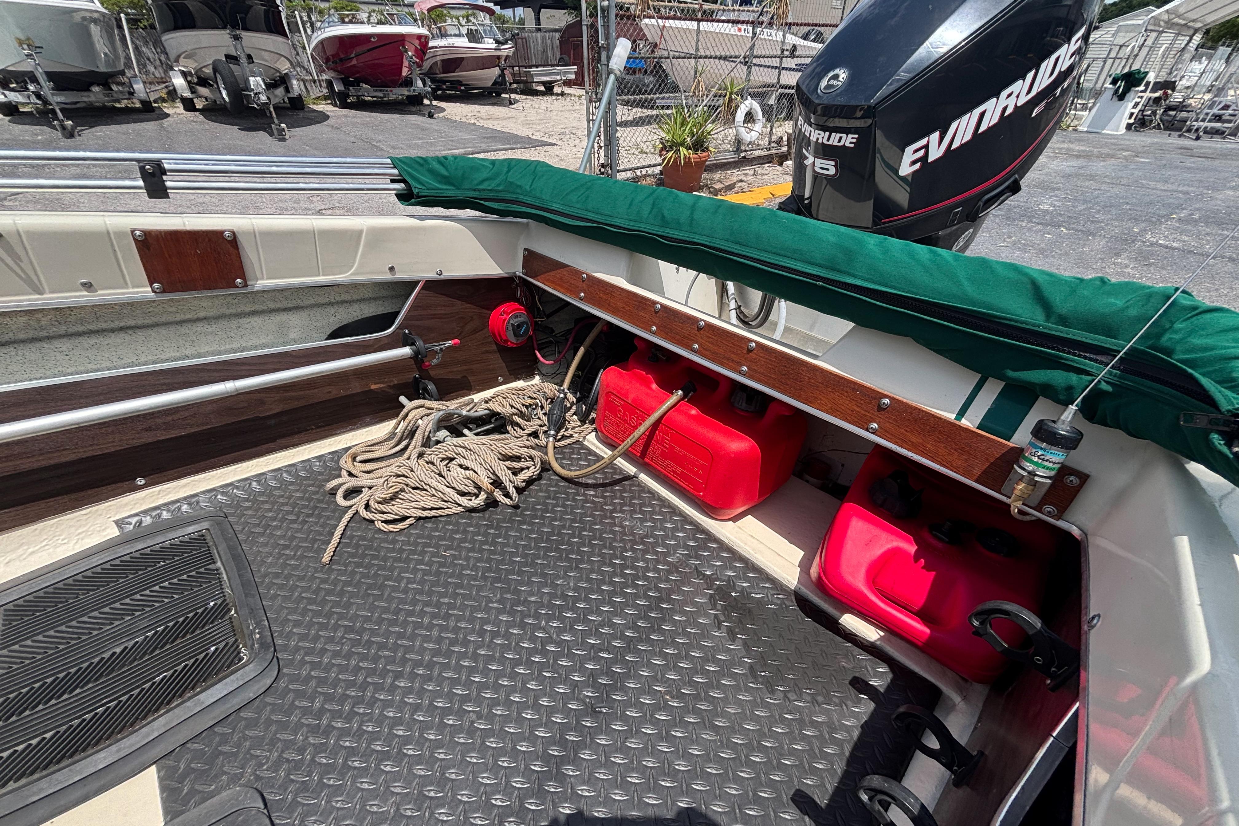Interior of a 1966 Mohawk 15 boat with Evinrude motor and red fuel tanks.