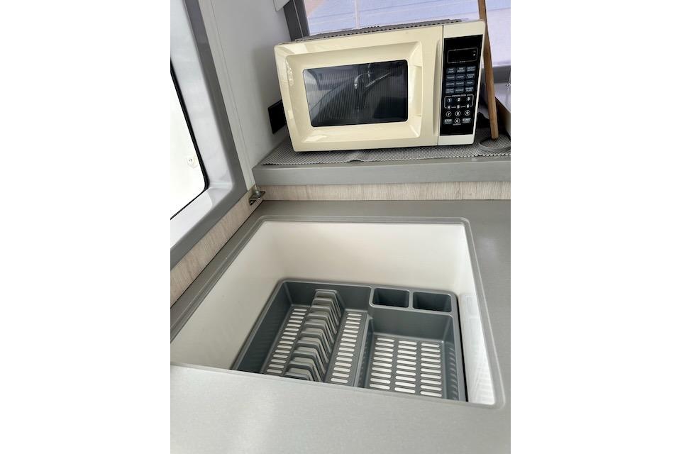 Modern kitchen area in a 2017 Leopard 40 yacht with microwave and sink.