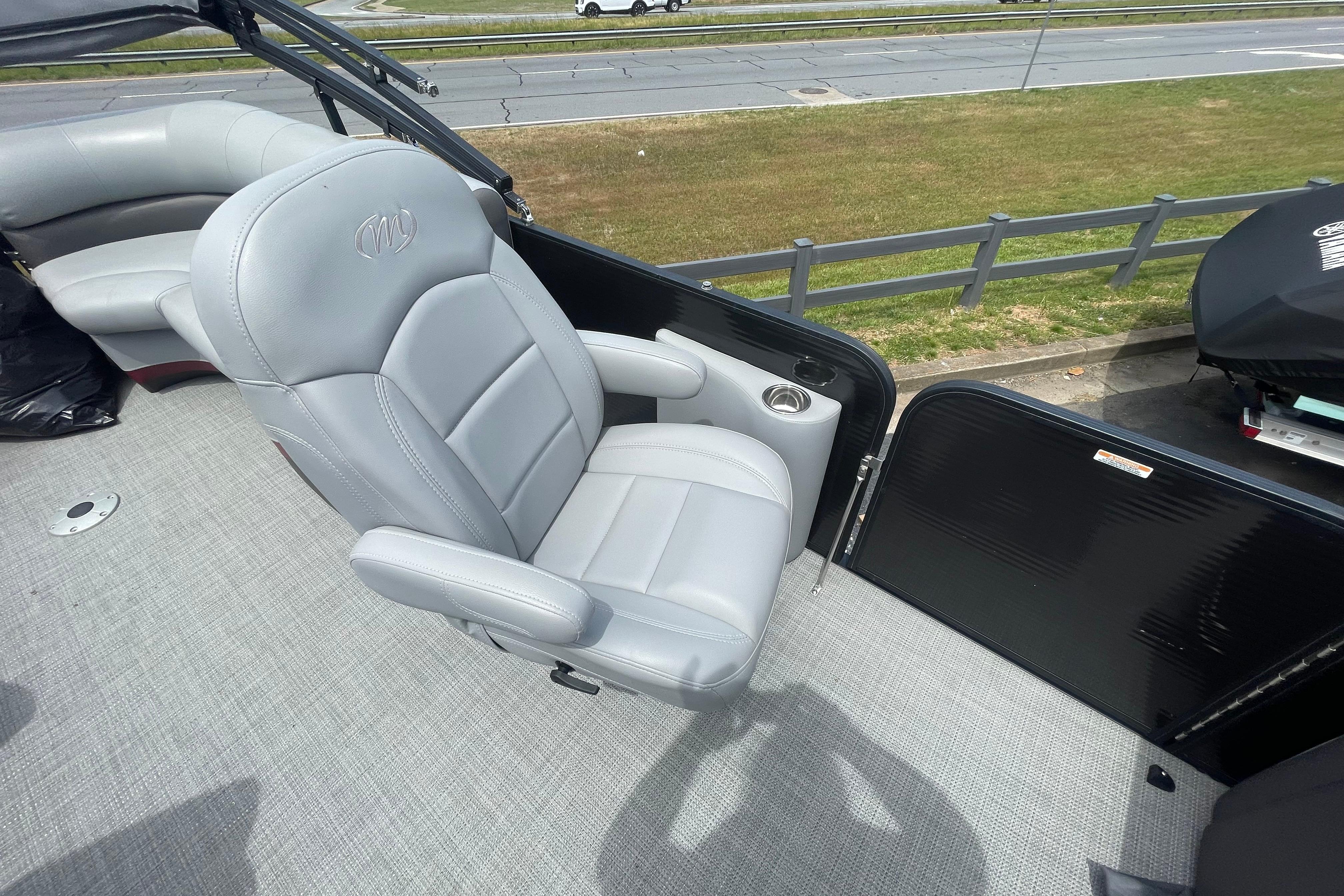 2022 Manitou 23 Oasis boat with gray captain's chair and spacious deck.