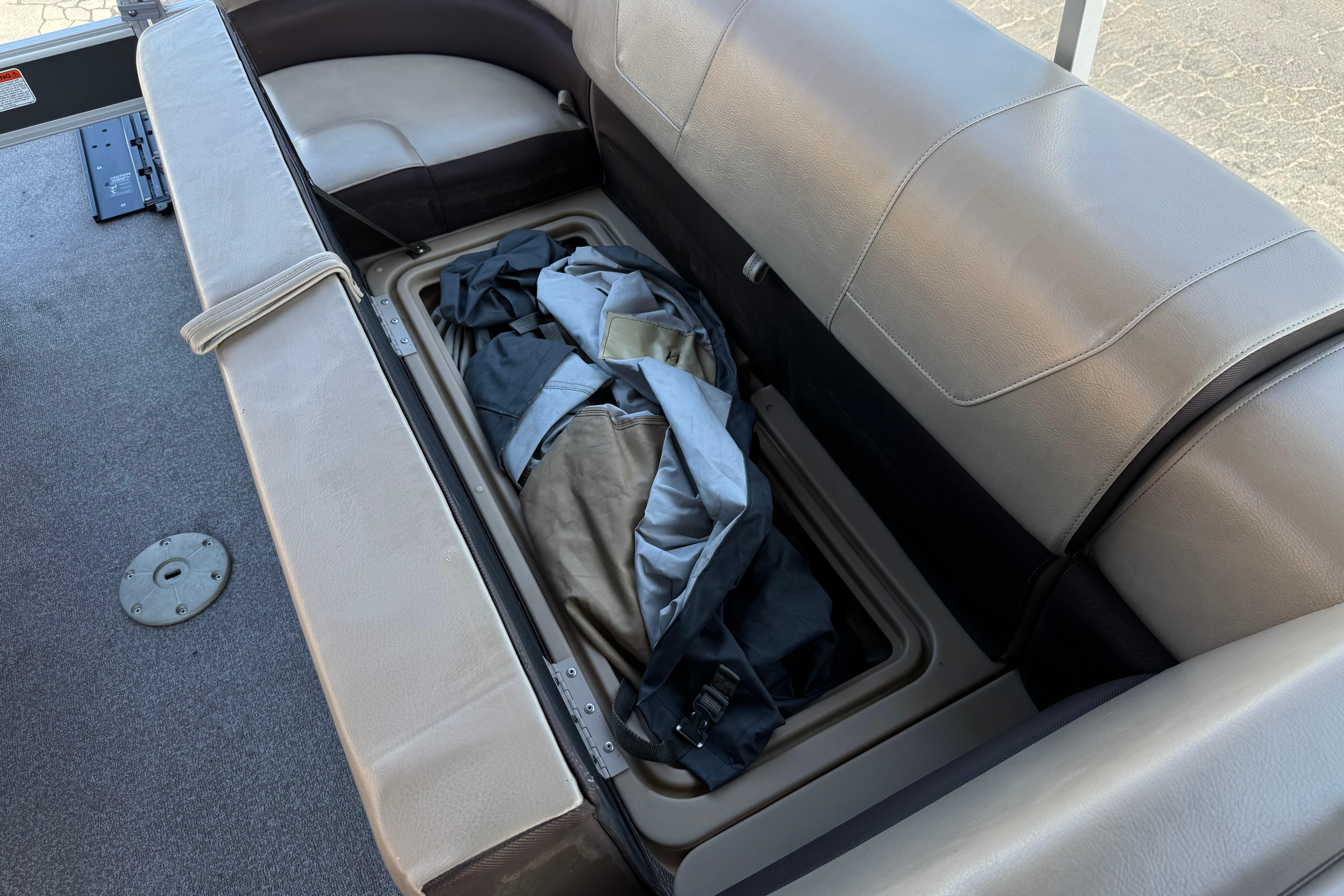 2018 Sun Tracker SportFish 22 DLX boat seat storage with gear inside.