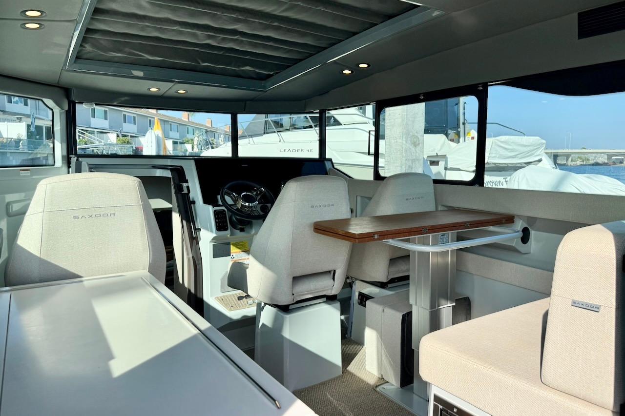 Interior of 2024 Saxdor 320 GTC boat, featuring modern seating and steering area.