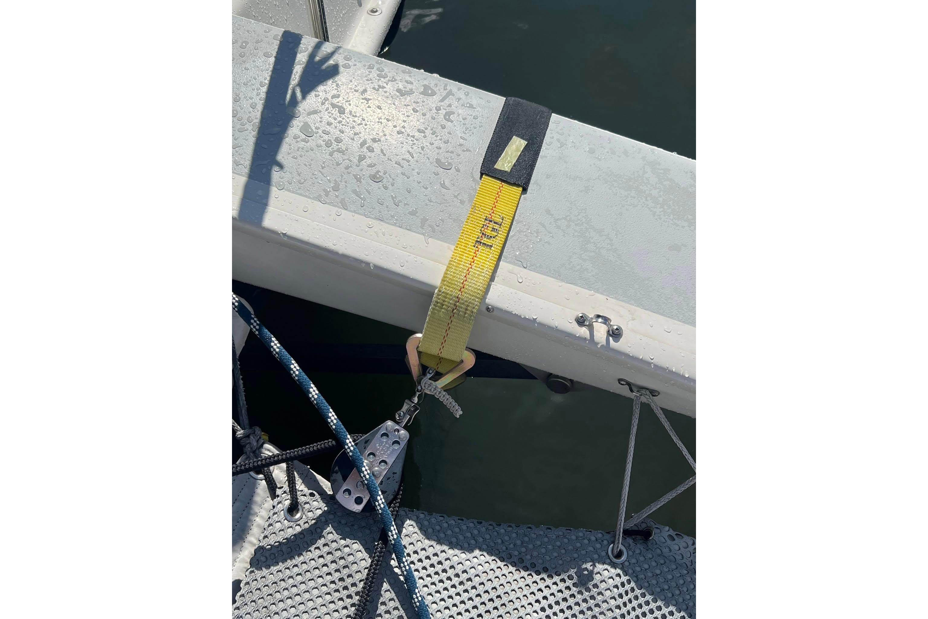 Yellow strap securing Corsair F-27 sailboat, 1993 model, with visible rigging and deck details.