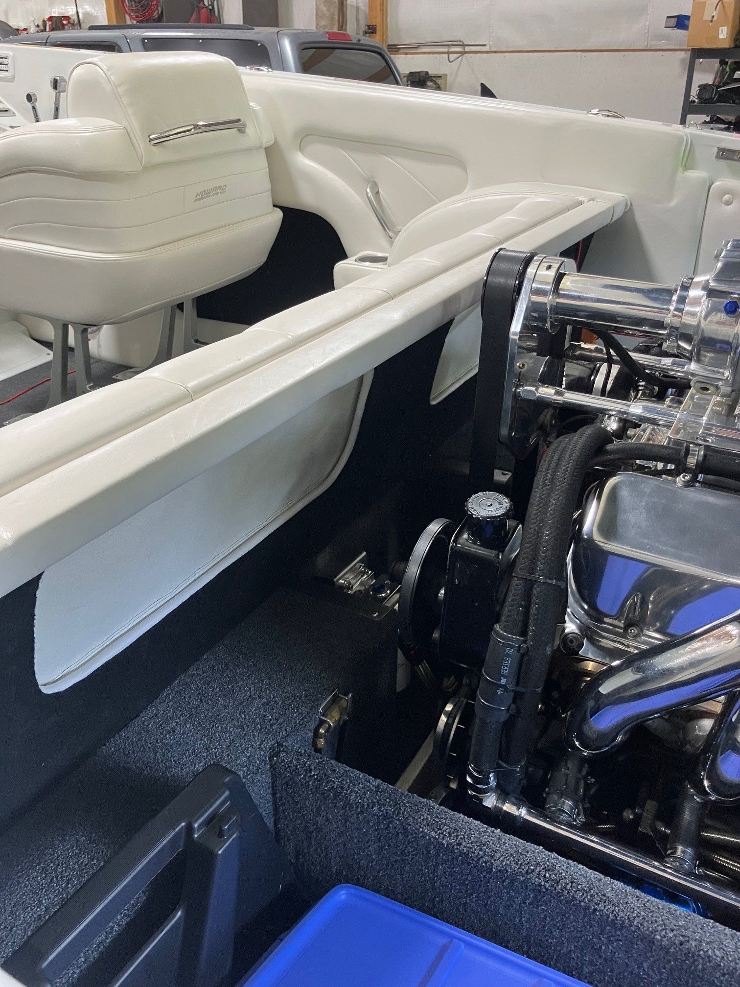 Interior view of a 2003 Howard Bullet boat with white upholstery and a shiny engine.