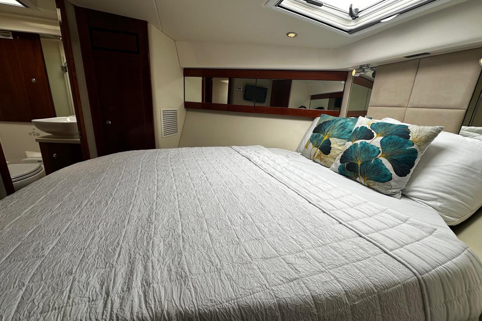 Luxurious bedroom interior of 2012 Riviera 43 Flybridge yacht with elegant bedding.