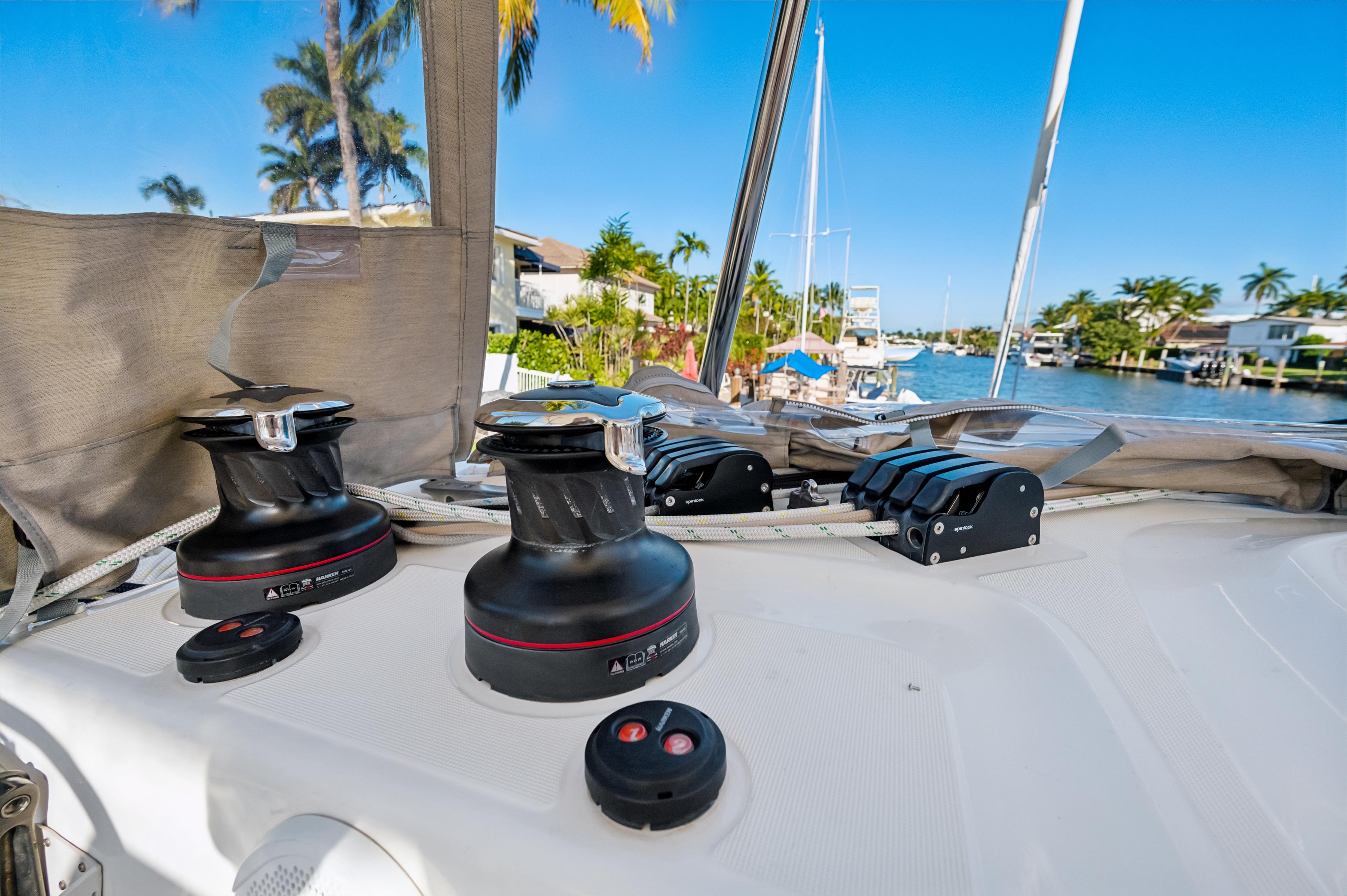2022 Lagoon 46 yacht deck with winches and tropical waterfront view.