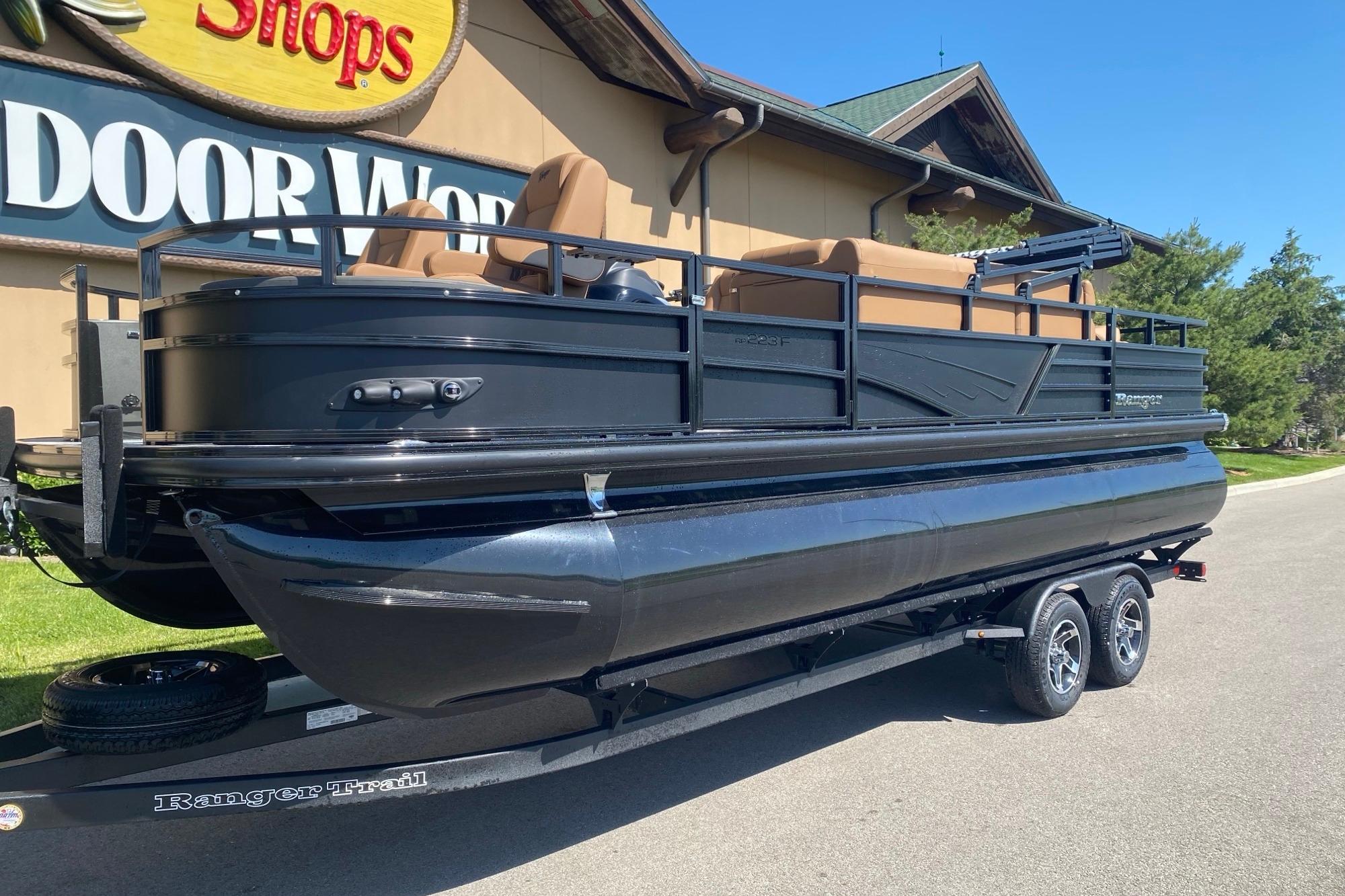 2026 Ranger 223F pontoon boat on trailer outside a store.