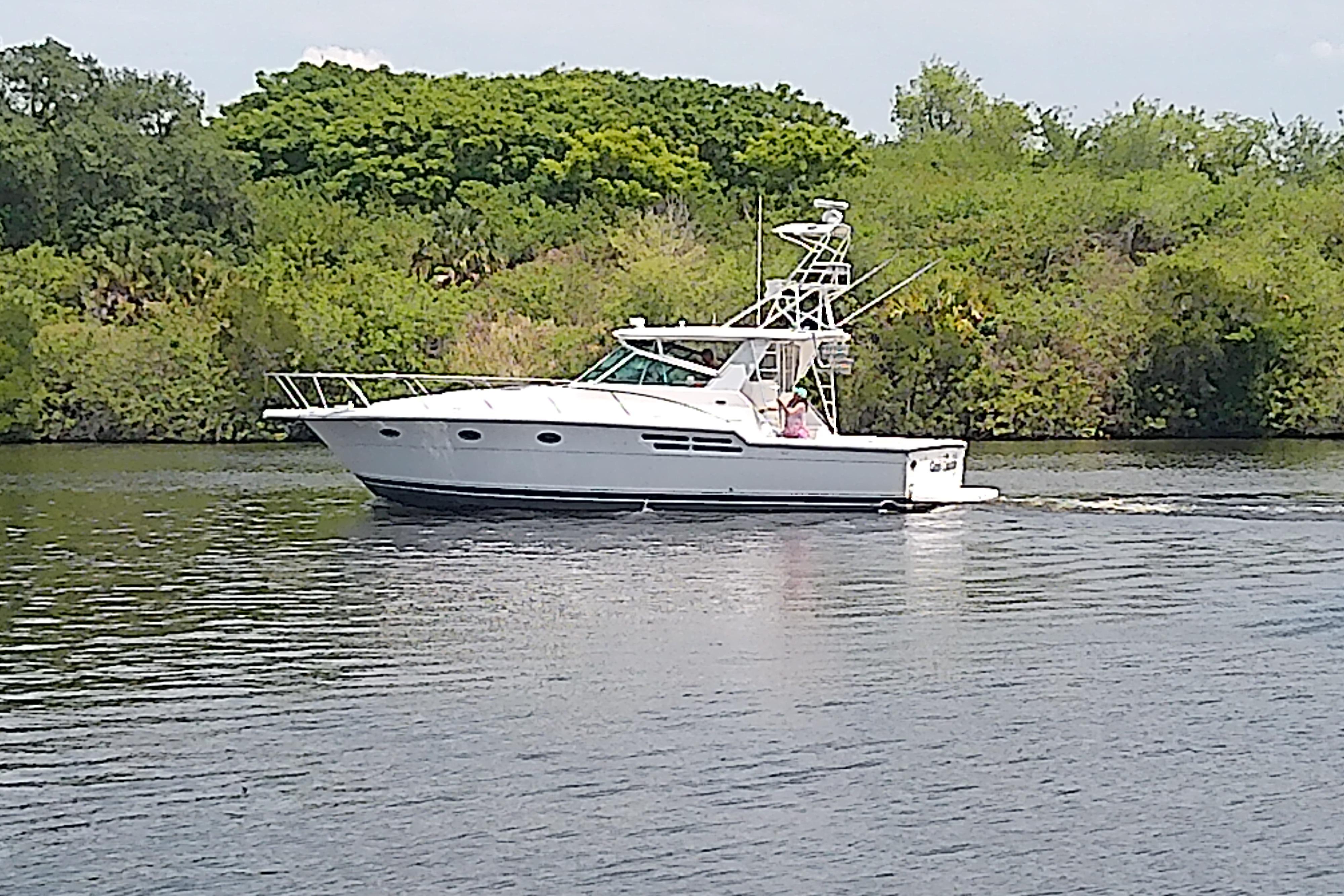2000 Tiara Yachts 4100 Open cruising on a serene river with lush greenery.