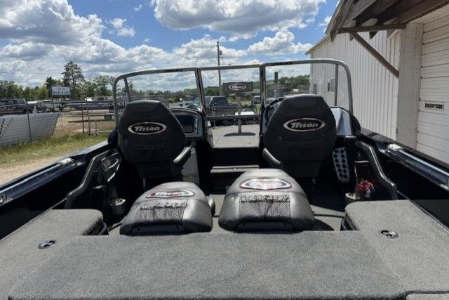 2016 Triton 216 Fishunter boat interior with seating, under a partly cloudy sky.