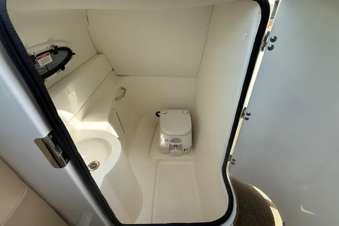 2014 Sea Ray 260 Sundeck boat interior with compact bathroom and toilet.