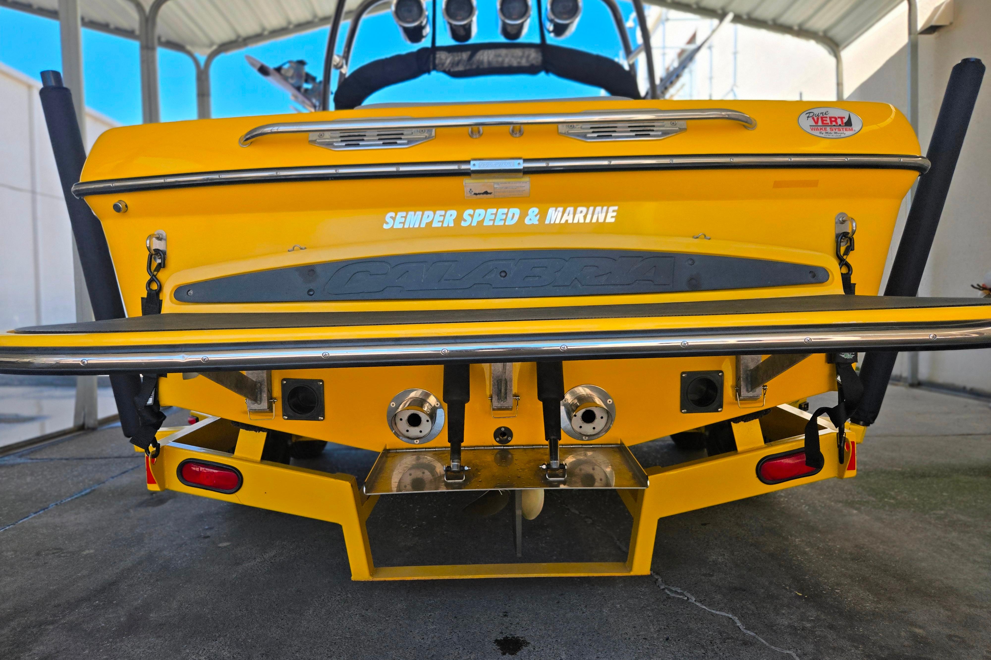 Rear view of a 2007 Calabria CAL AIR PRO V boat, yellow with marine equipment.