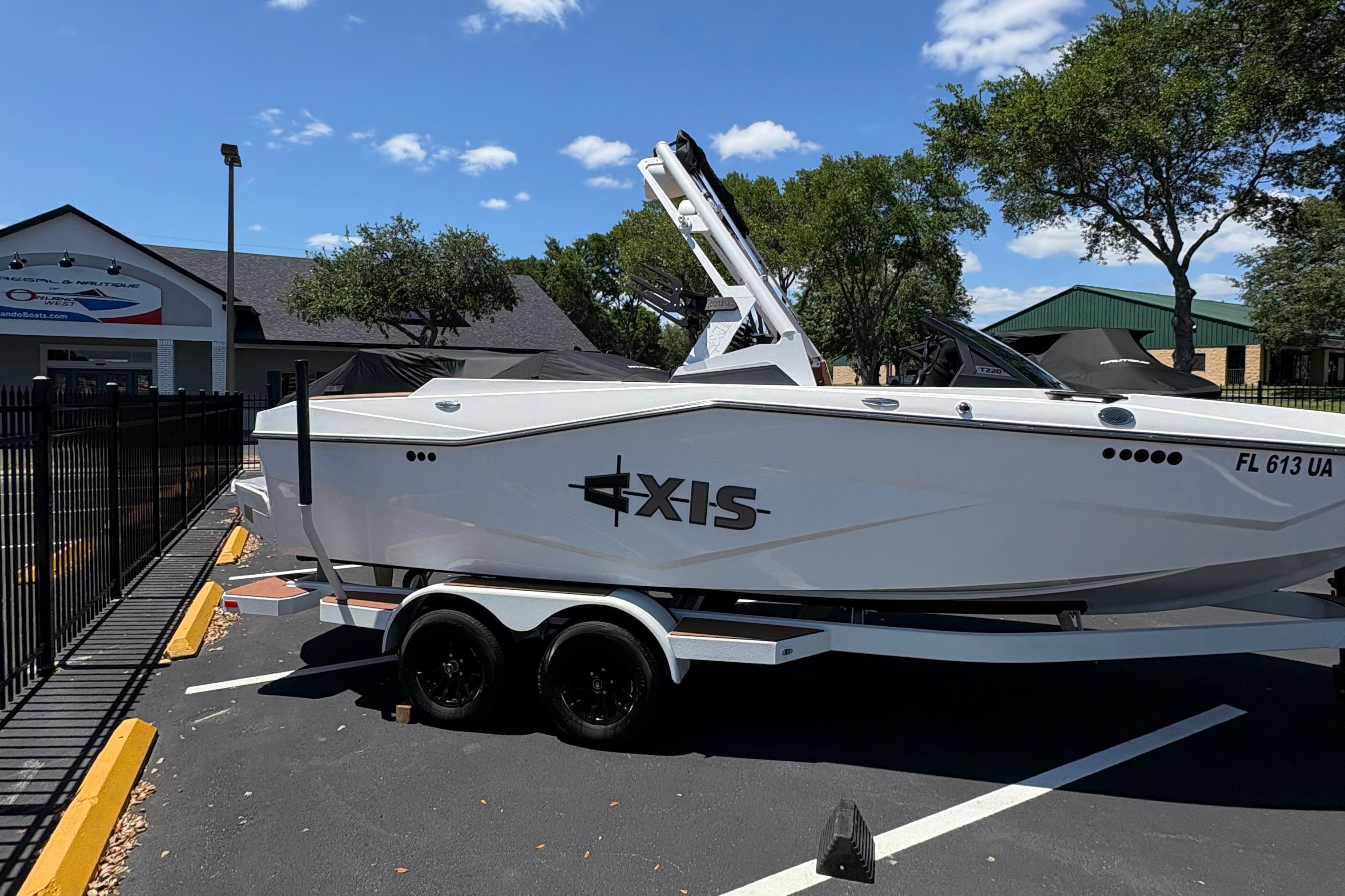 2025 Axis T220 boat on trailer in parking lot, sunny day, dealership in background.