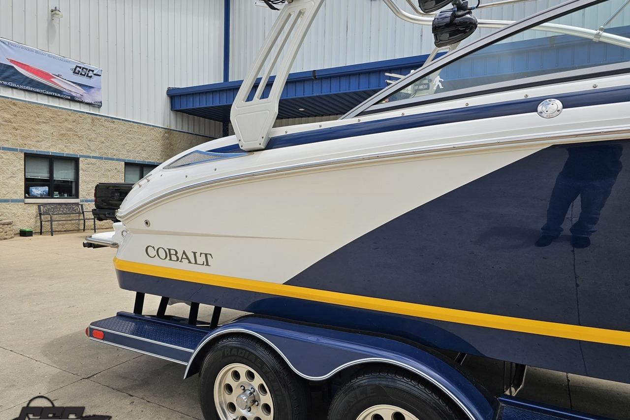 2010 Cobalt 232 WSS boat on trailer, parked outside a building.