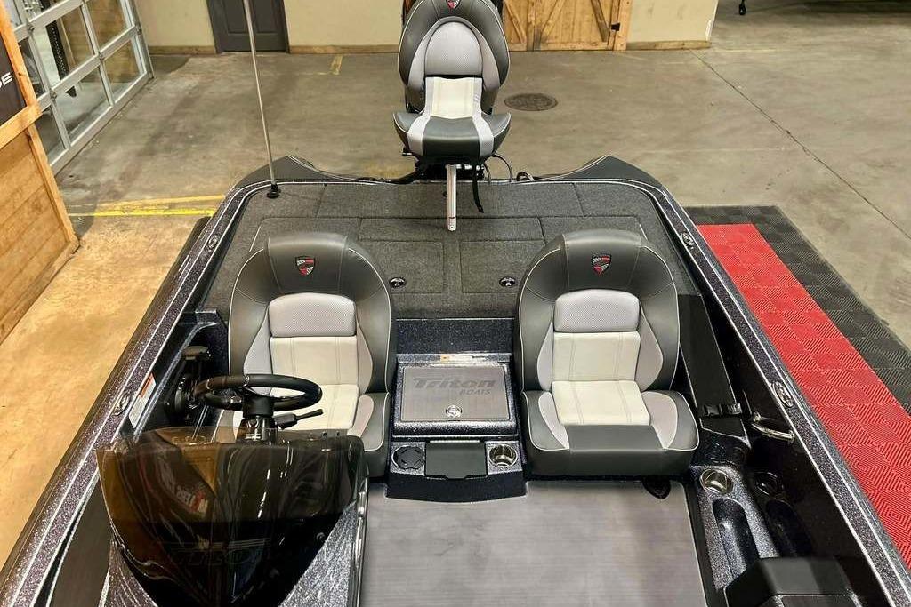 2026 Triton 18 TrX boat interior with dual seats and steering wheel in showroom.