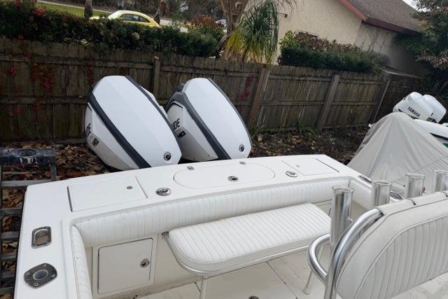 2002 Regulator 26 Forward Seating boat with dual outboard engines, parked outdoors.