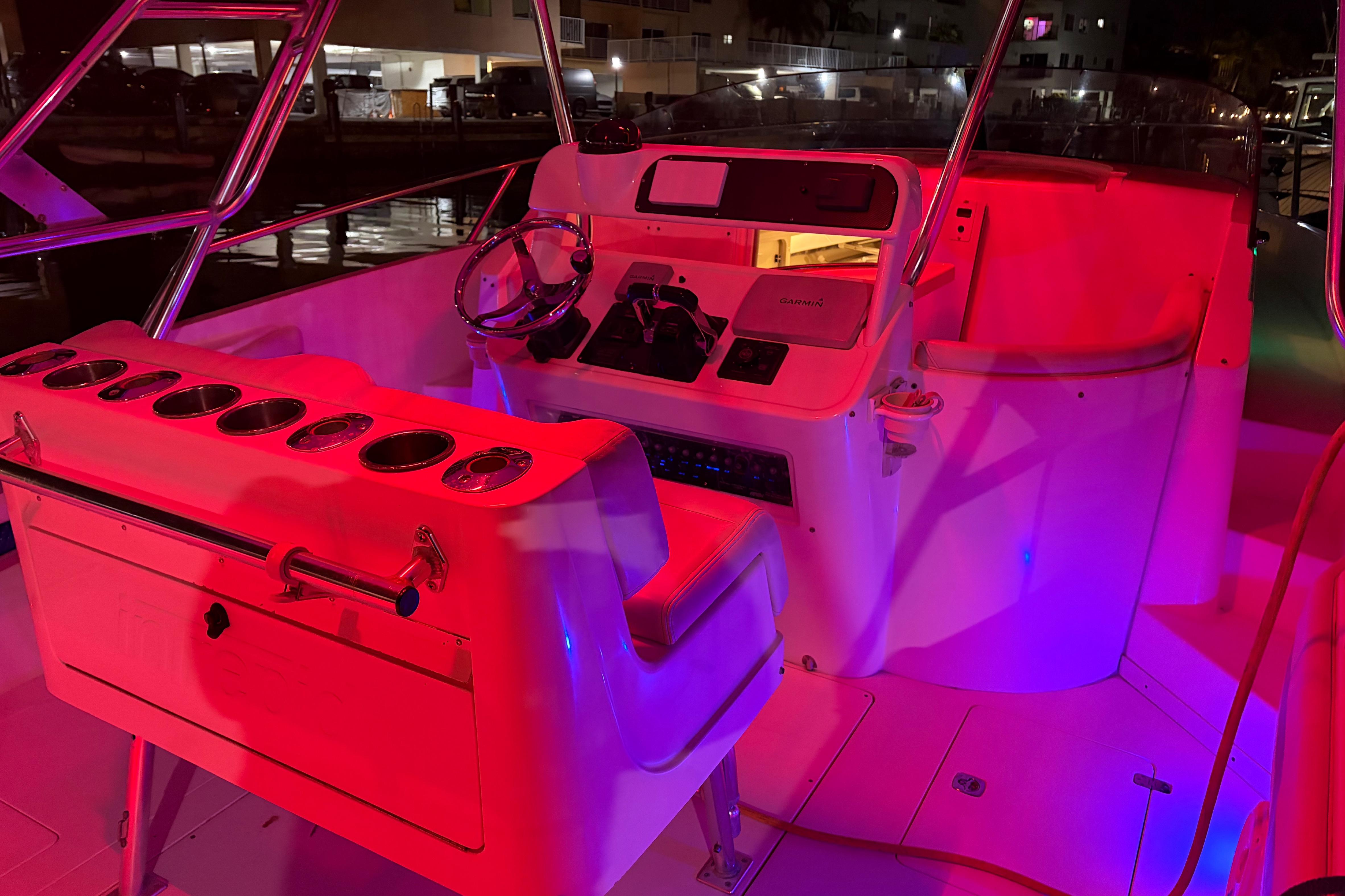1998 Intrepid 339 Walkaround boat interior with vibrant red and blue lighting.