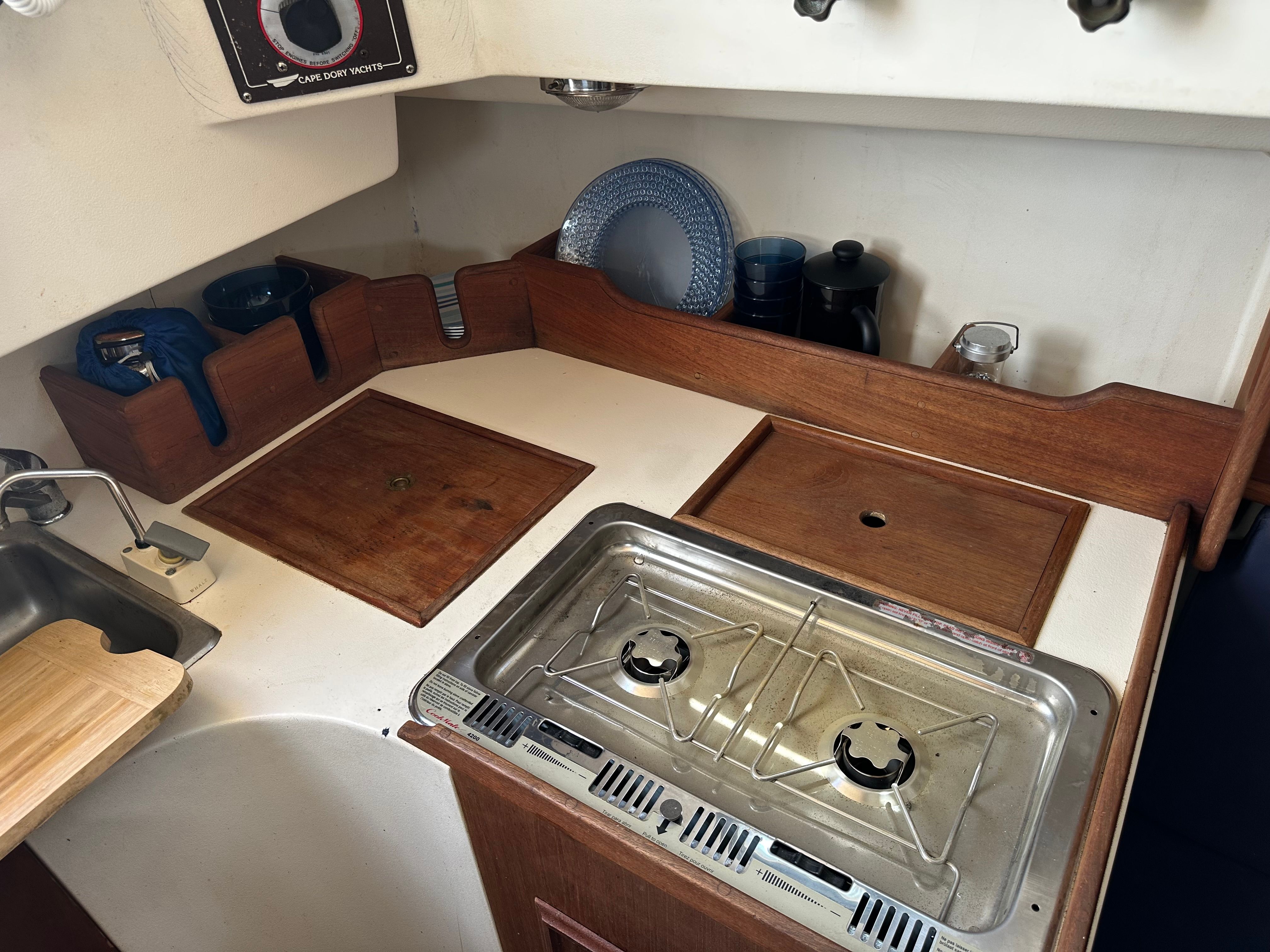Interior of the 1985 Cape Dory 25D featuring a small kitchen and gas stove.