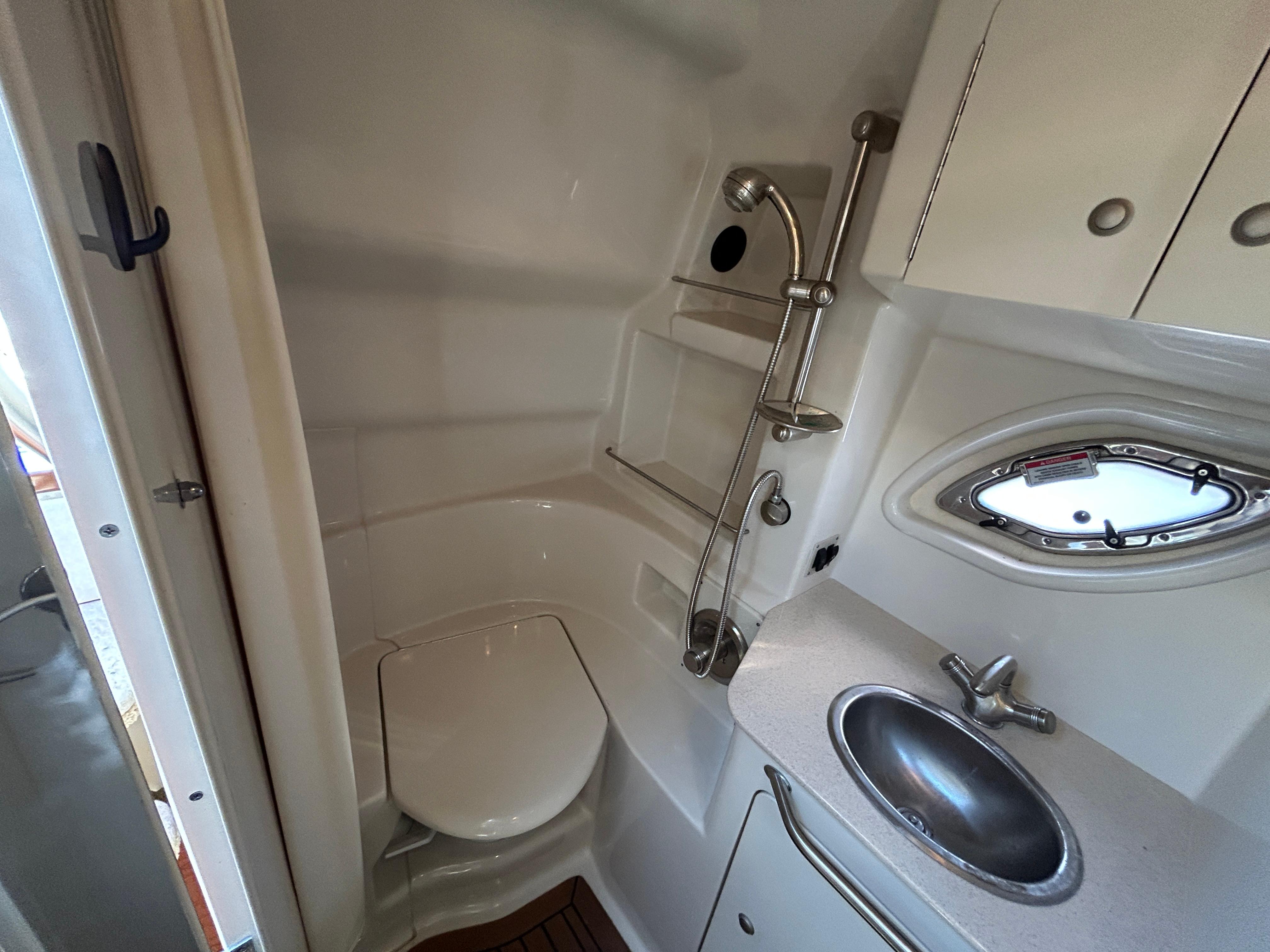 2008 Sea Ray 330 Sundancer bathroom with toilet, sink, and showerhead.