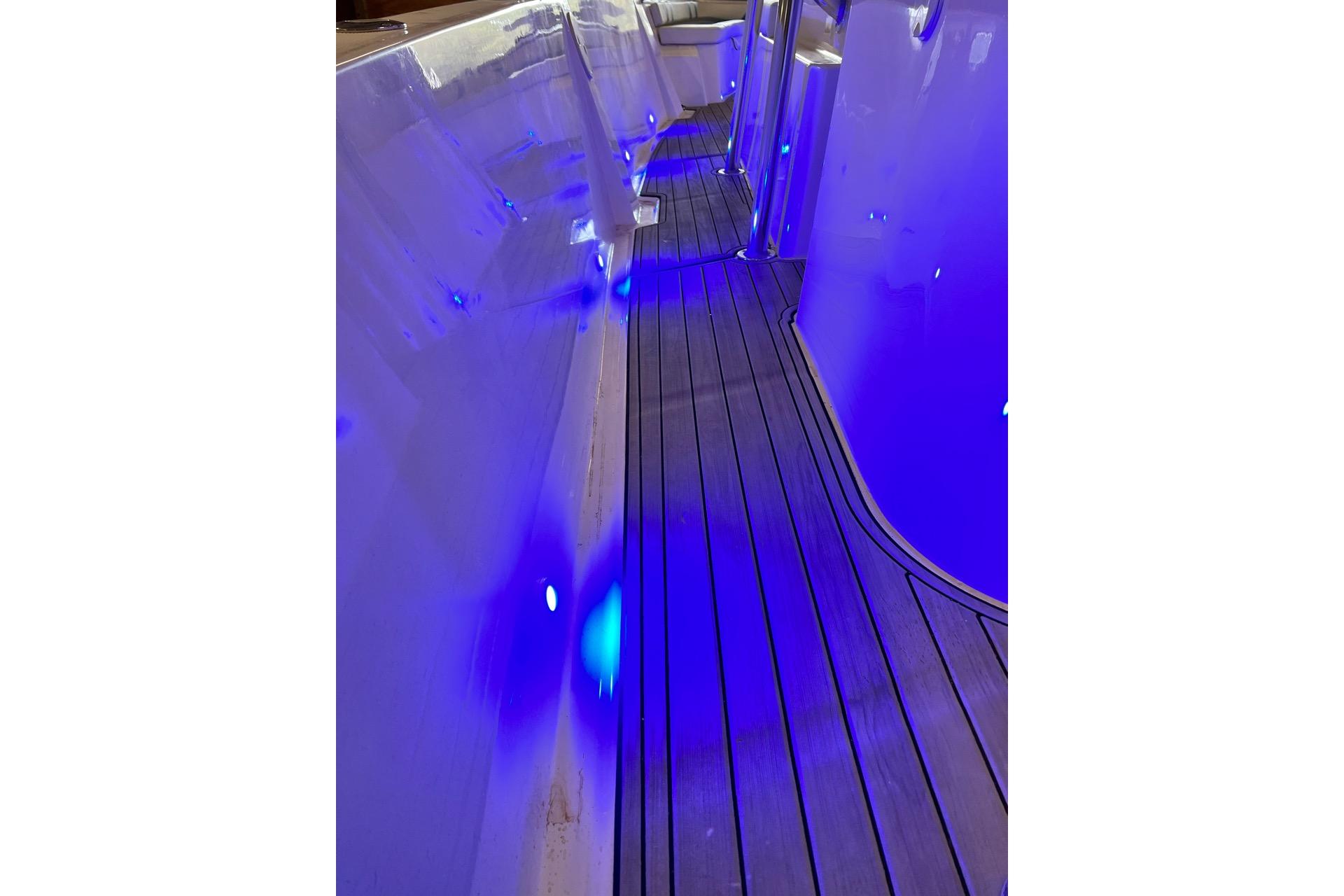 Custom Infusion 34 CC 2021 boat interior with blue LED lighting and sleek wooden flooring.