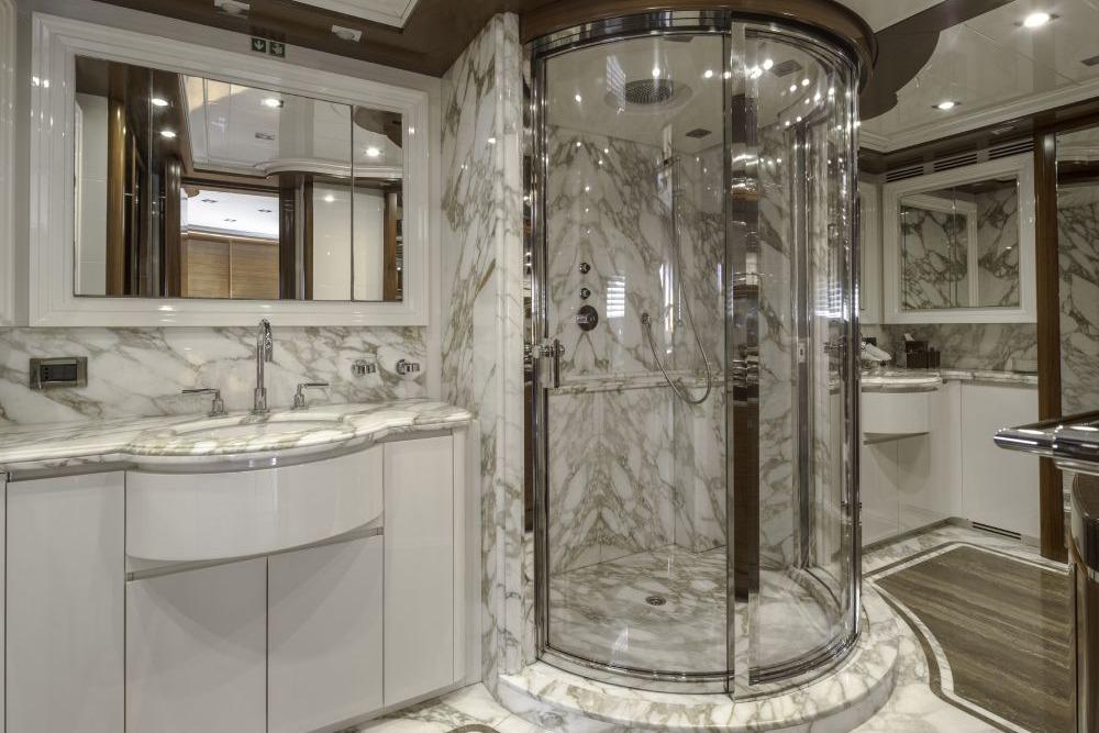 Luxurious marble bathroom with glass shower in 2009 CRN 129 yacht.