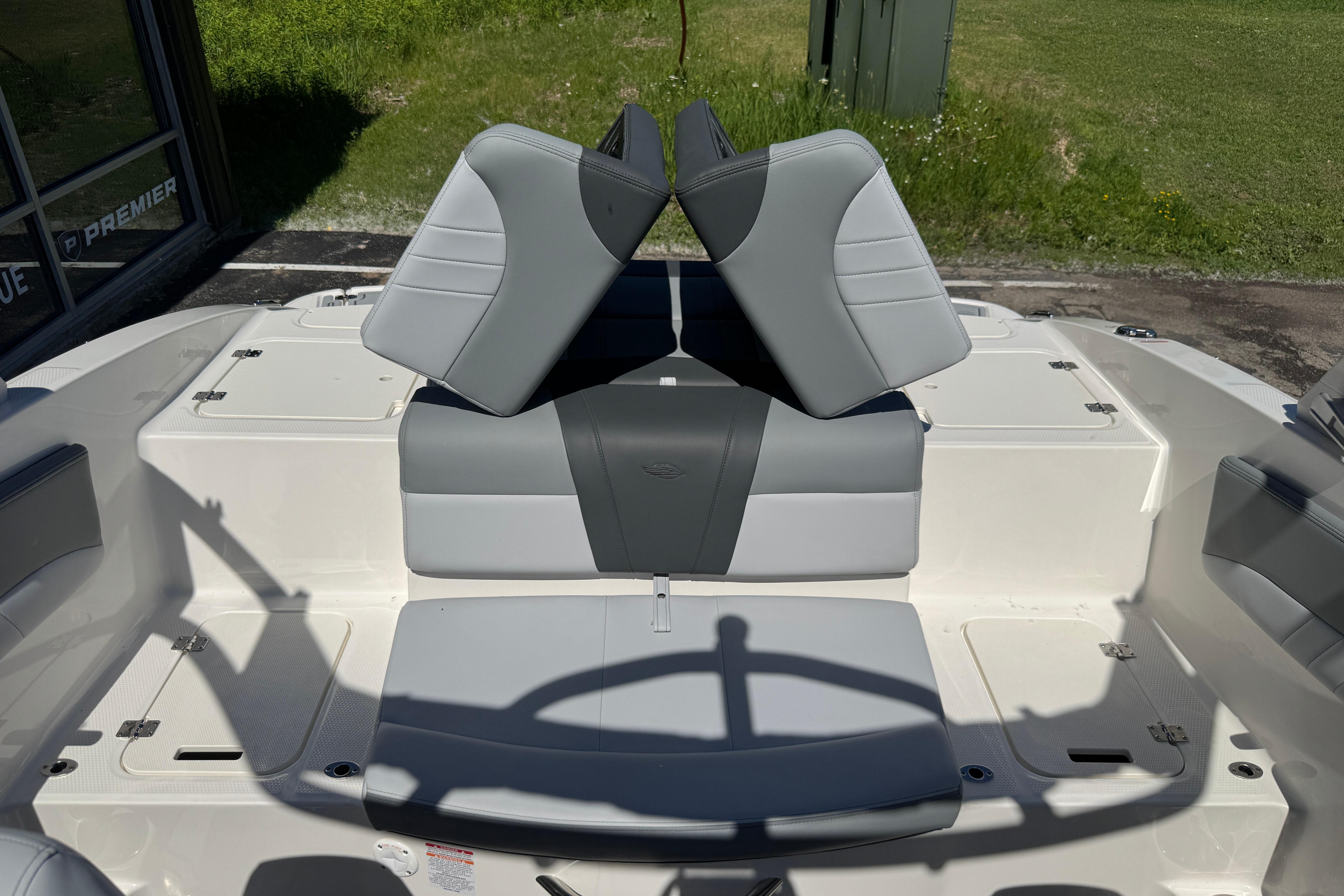 2026 Chaparral 21 SSi boat interior with gray and white seating, outdoor setting.