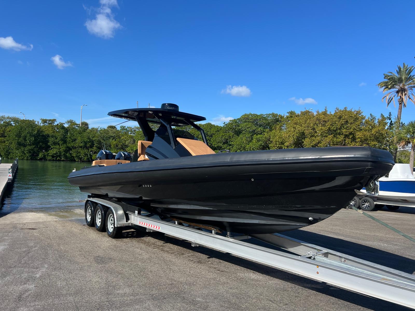 2026 Novielli Veloche 349 boat on trailer, sleek black design, sunny day, waterfront background.