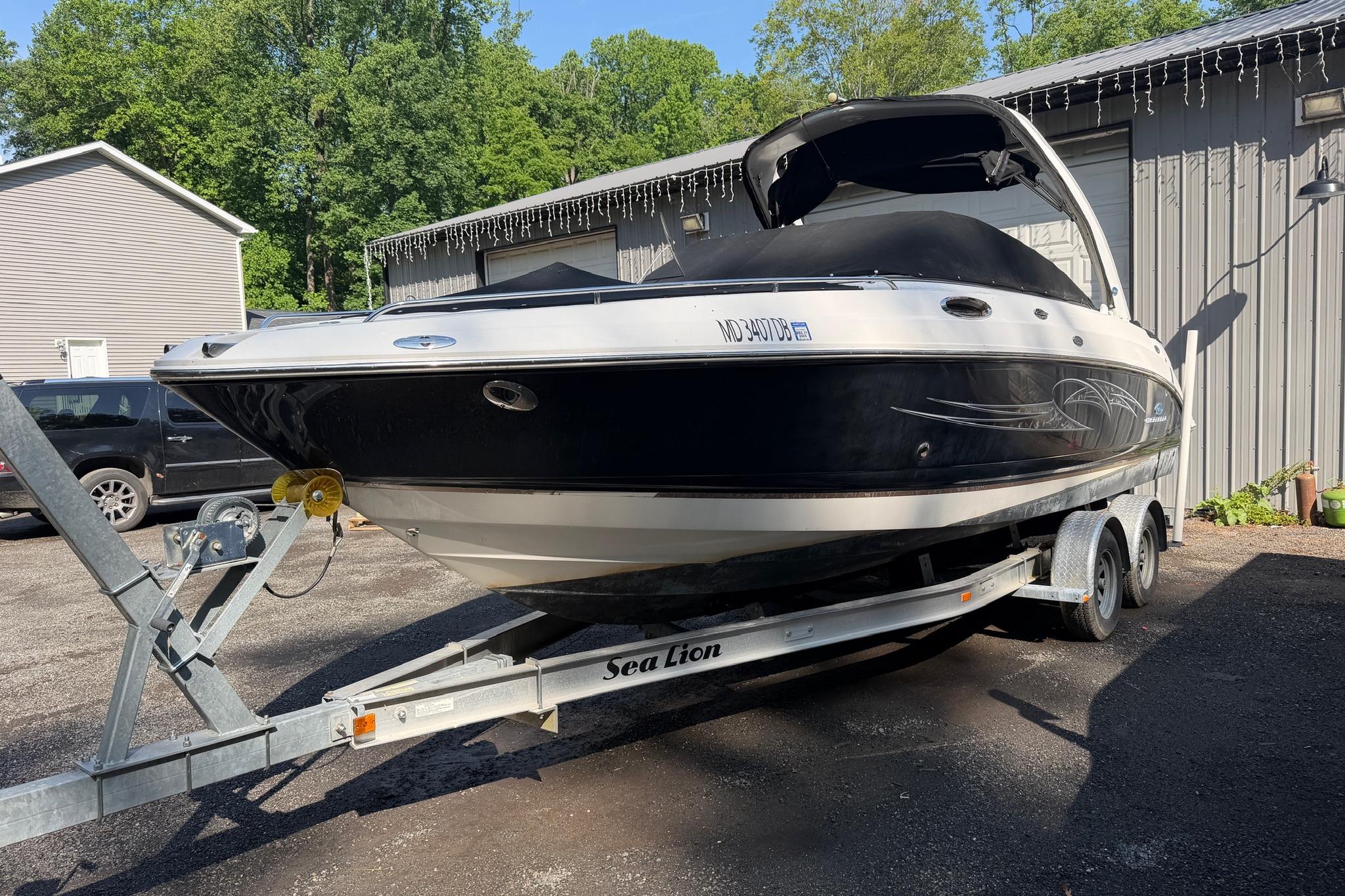 2005 Chaparral 256 SSi boat on trailer, parked outdoors near a building.