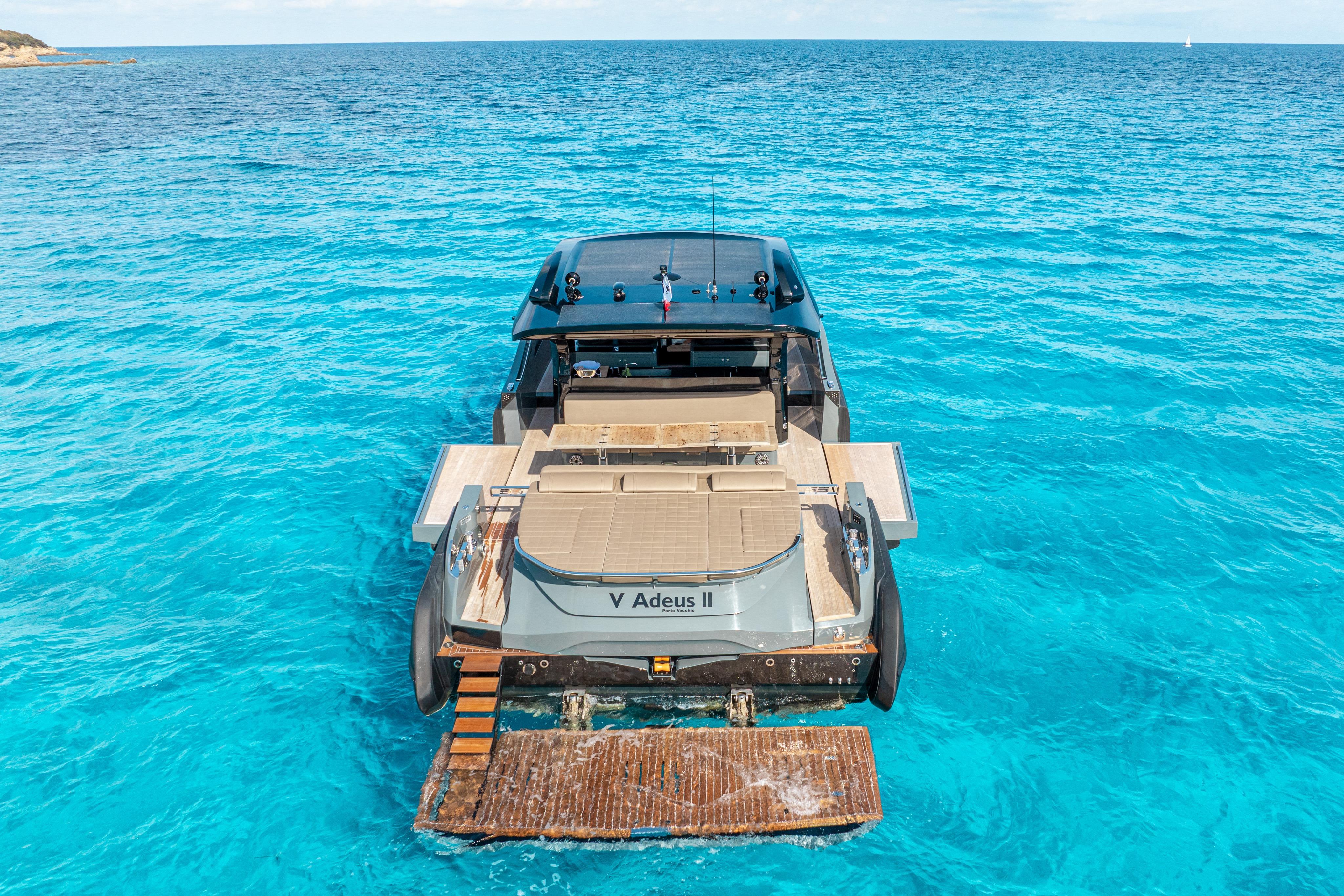 2024 SACS Rebel 55 yacht on clear blue ocean waters, rear view.