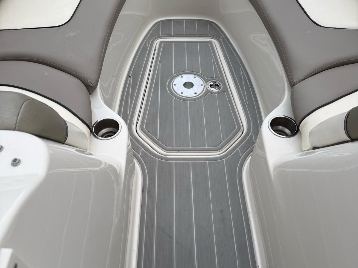 The image shows the deck area of a 2007 Sea Ray 240 Sundeck boat with gray flooring and cup holders.