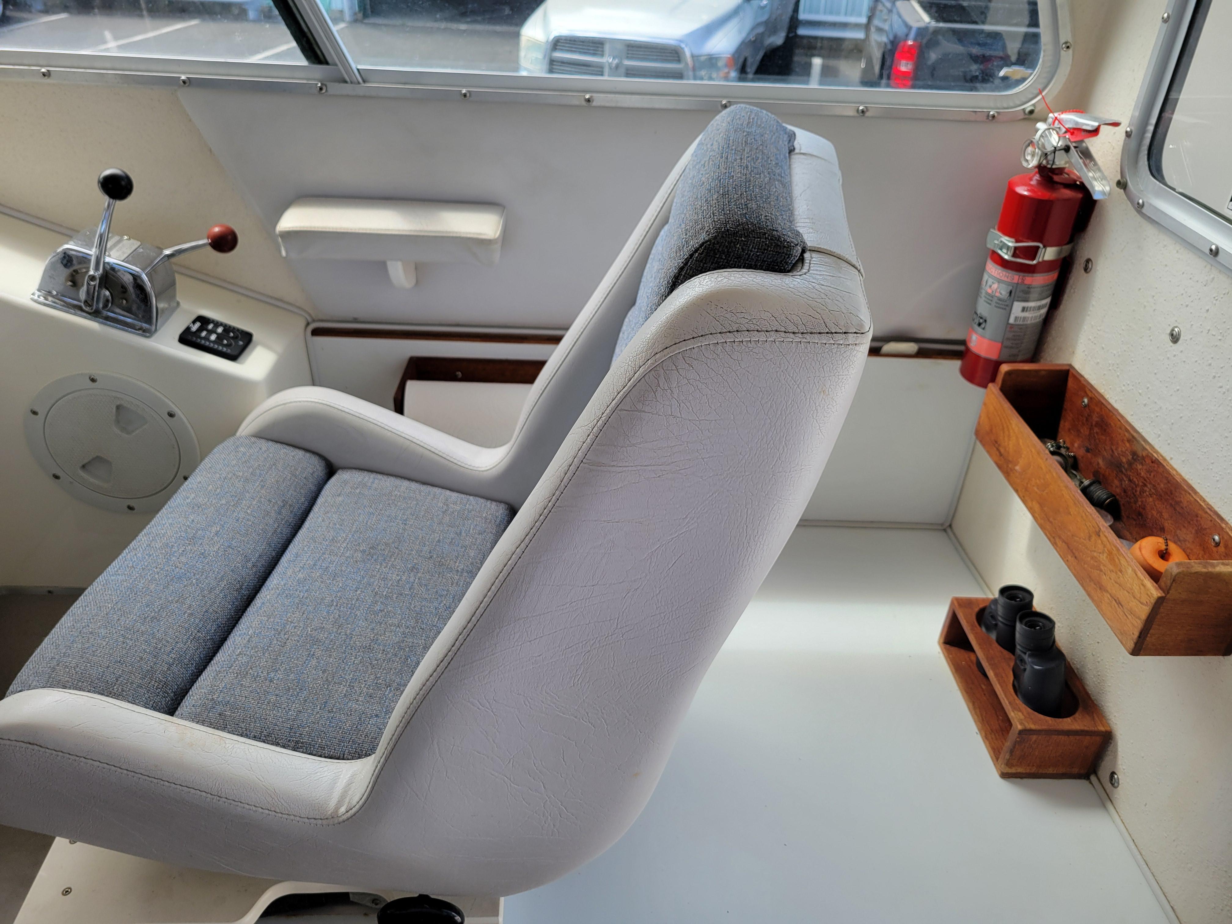 Interior of a 1999 SeaSport 2400 XL Limited boat with captain's chair and controls.
