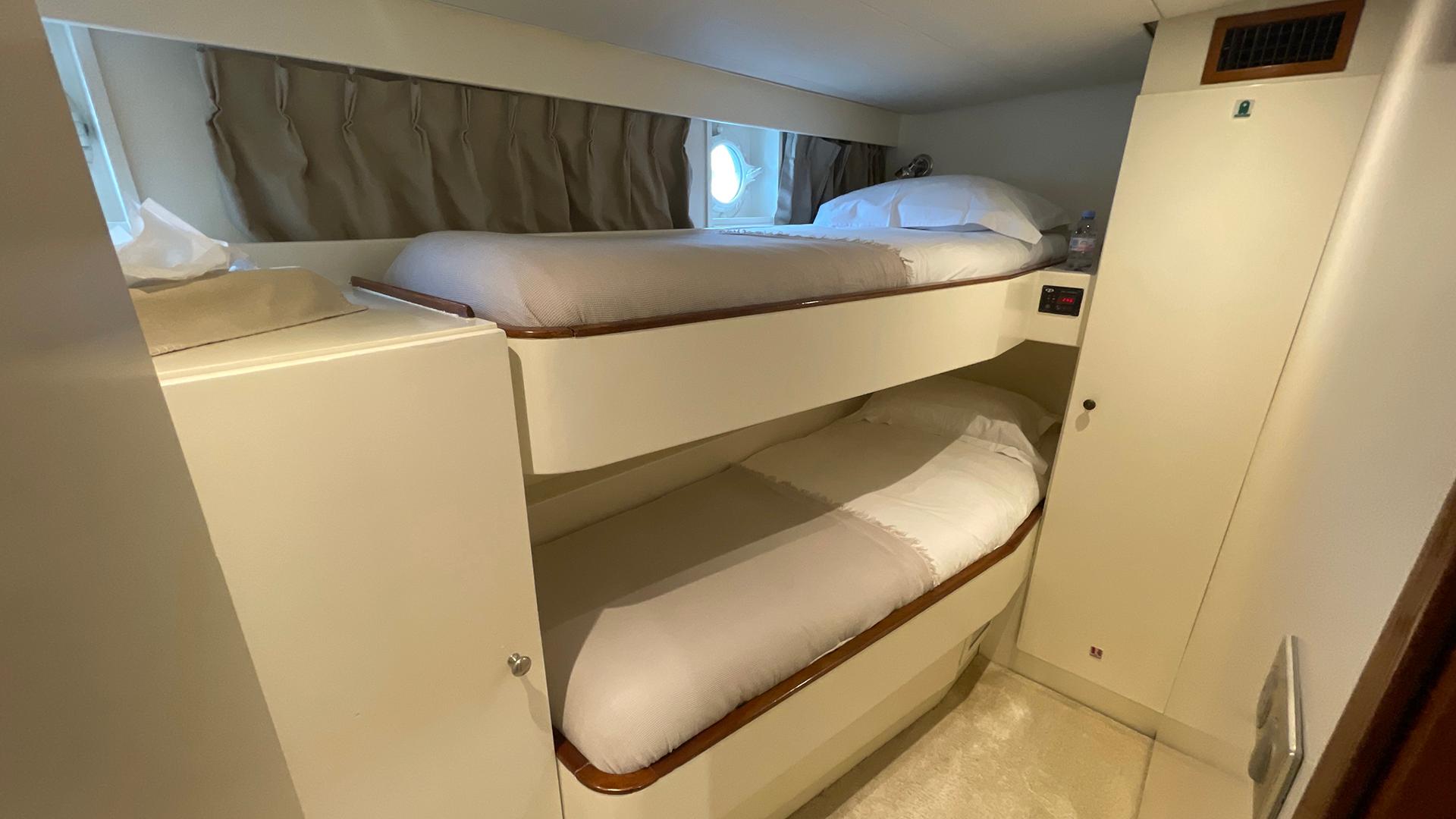 Bunk beds in a 1958 De Vries Lentsch 2300 yacht cabin, featuring cozy bedding and storage.
