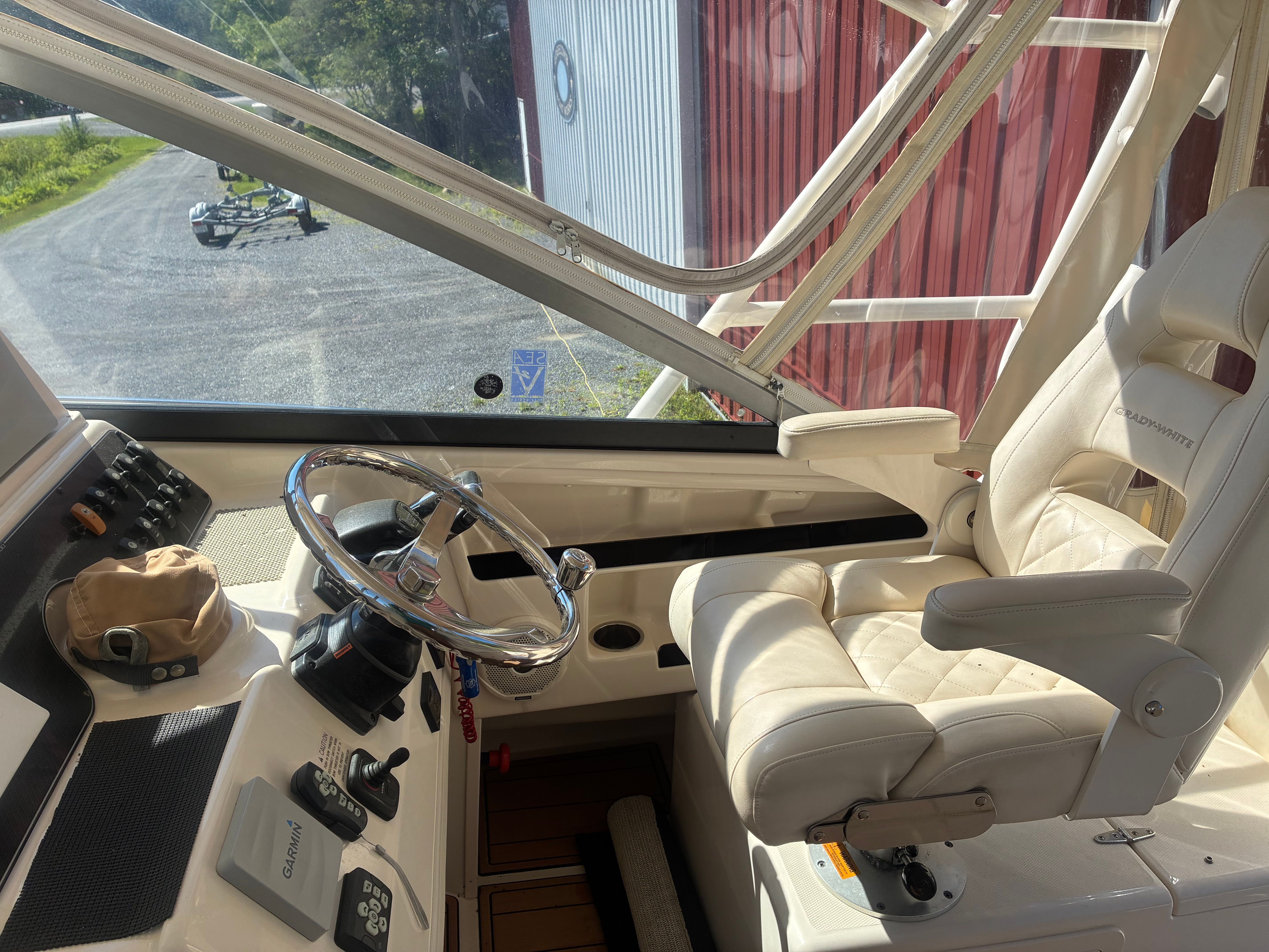 Interior view of a 2017 Grady-White Marlin 300 with a luxurious captain's chair and helm.