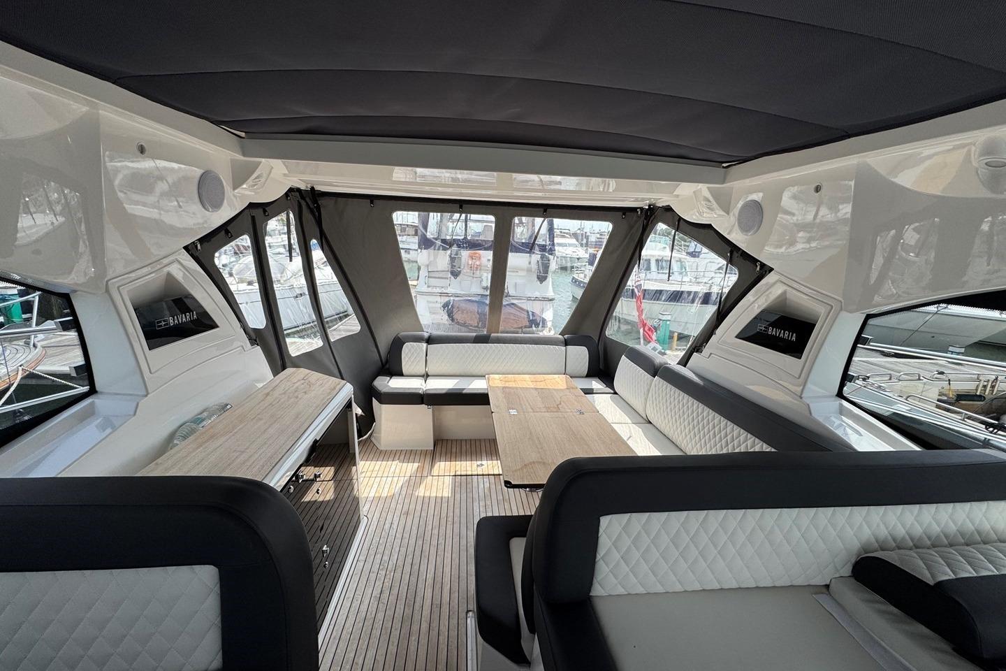 Luxurious interior of 2023 Bavaria SR41 yacht with elegant seating and wooden table.