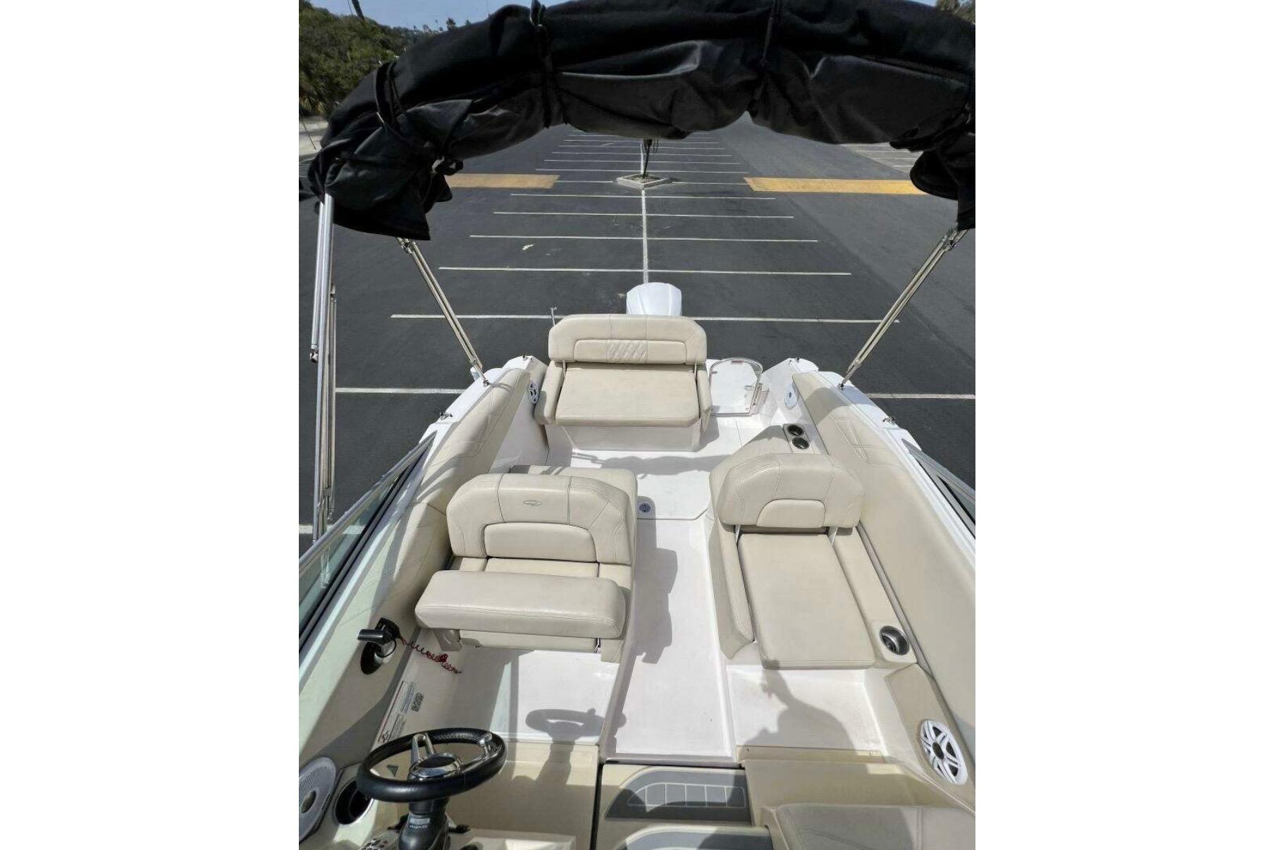 2019 Regal 26 XO boat interior with beige seating and black canopy in a parking lot.