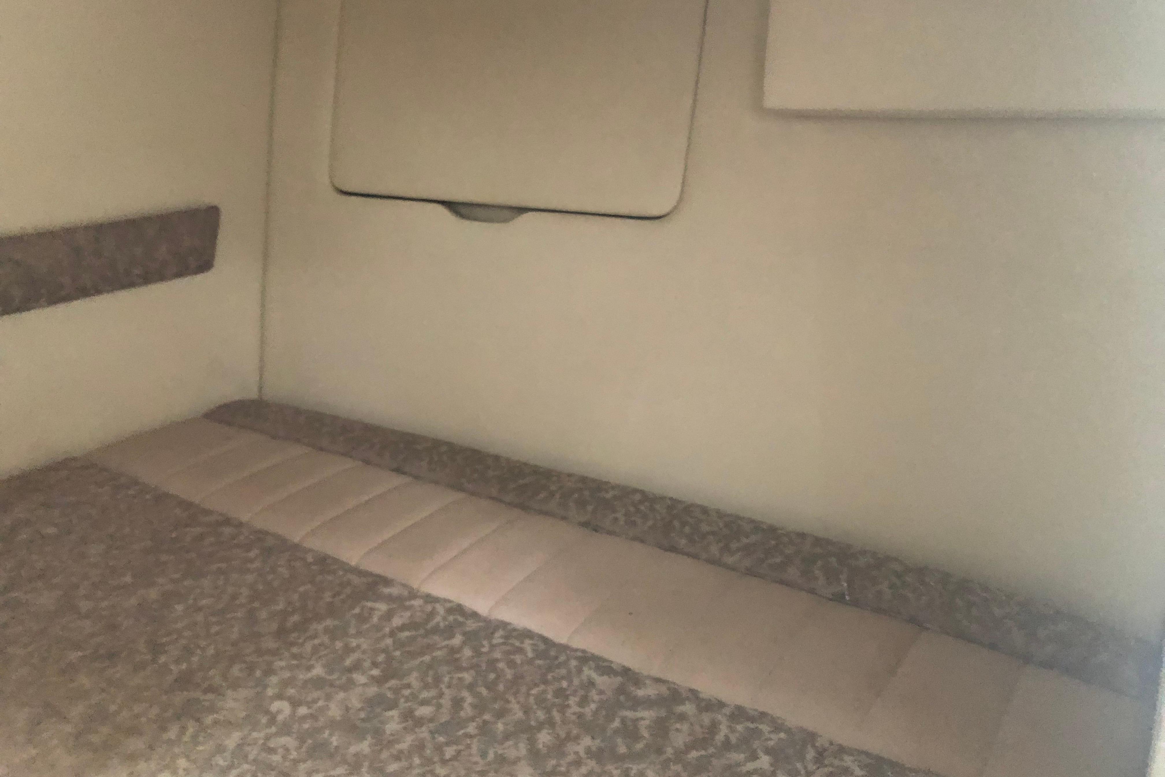 Interior cabin of a 1995 Maxum 3200 SCR boat, featuring a cushioned sleeping area.
