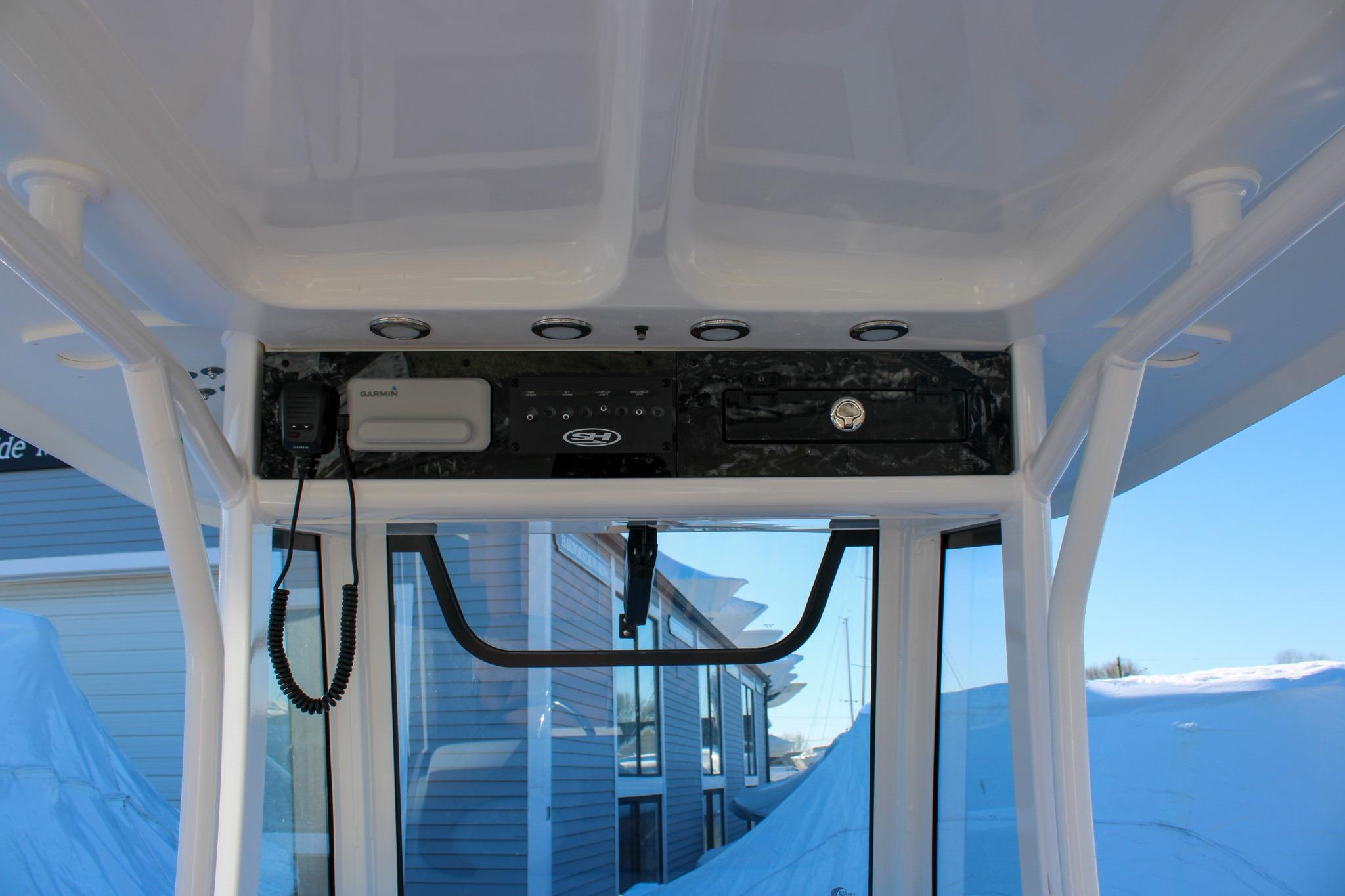 2026 Sea Hunt Gamefish 25 boat console with Garmin equipment and overhead storage.