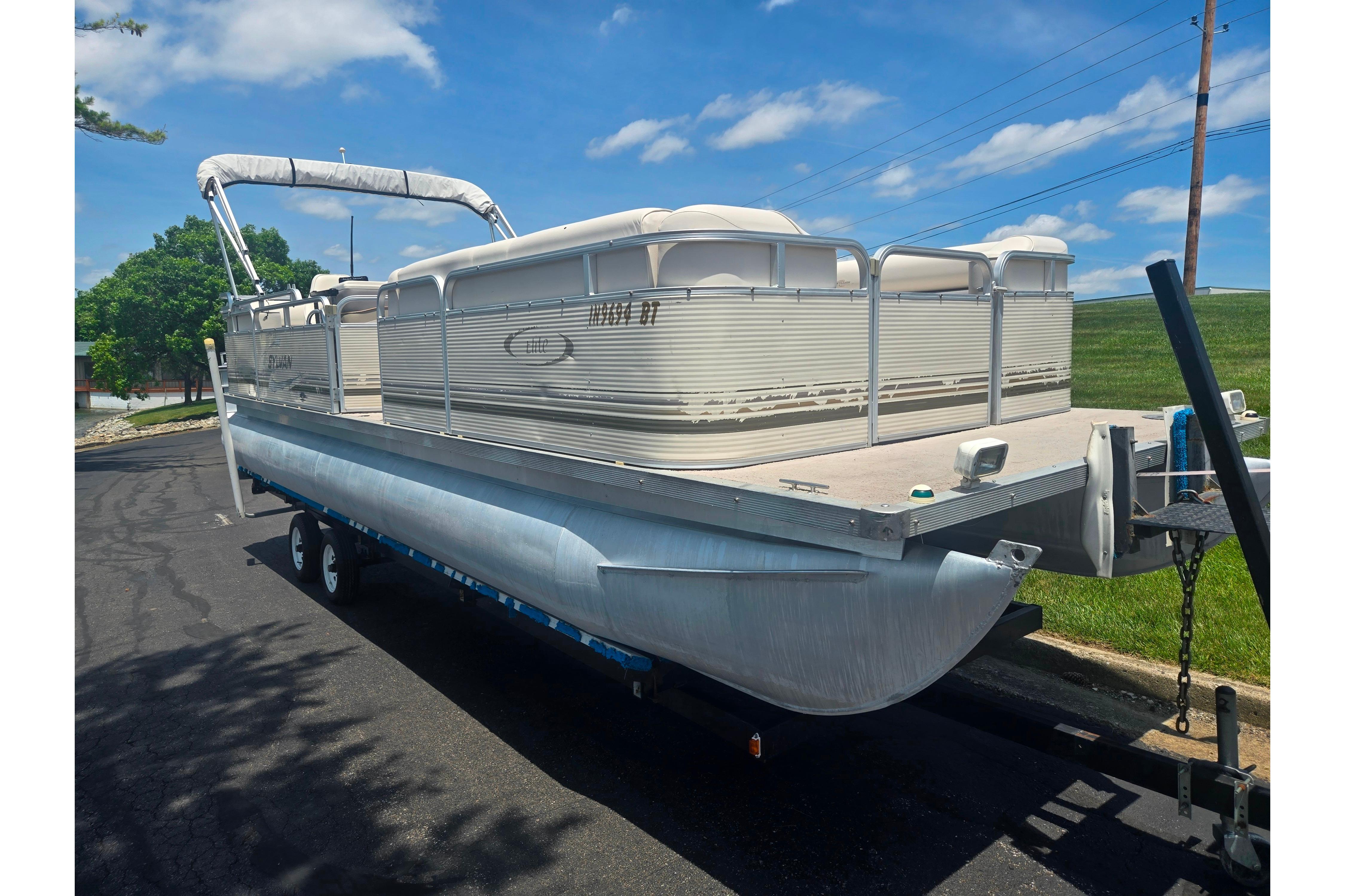 2000 Sylvan 824 Elite Cruise pontoon boat on trailer, parked on sunny day.