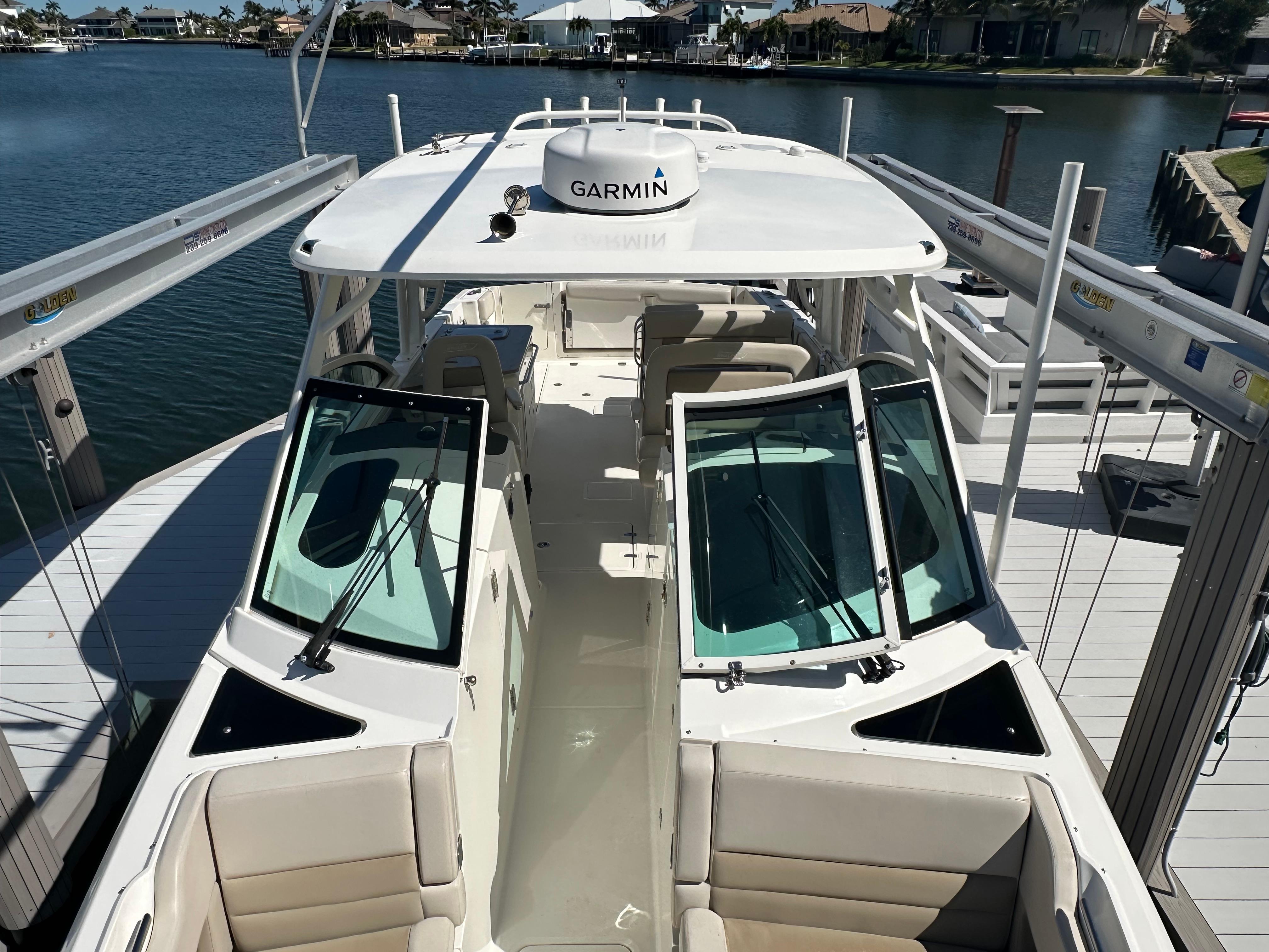 2018 Boston Whaler 320 Vantage boat docked, featuring Garmin equipment and spacious seating.