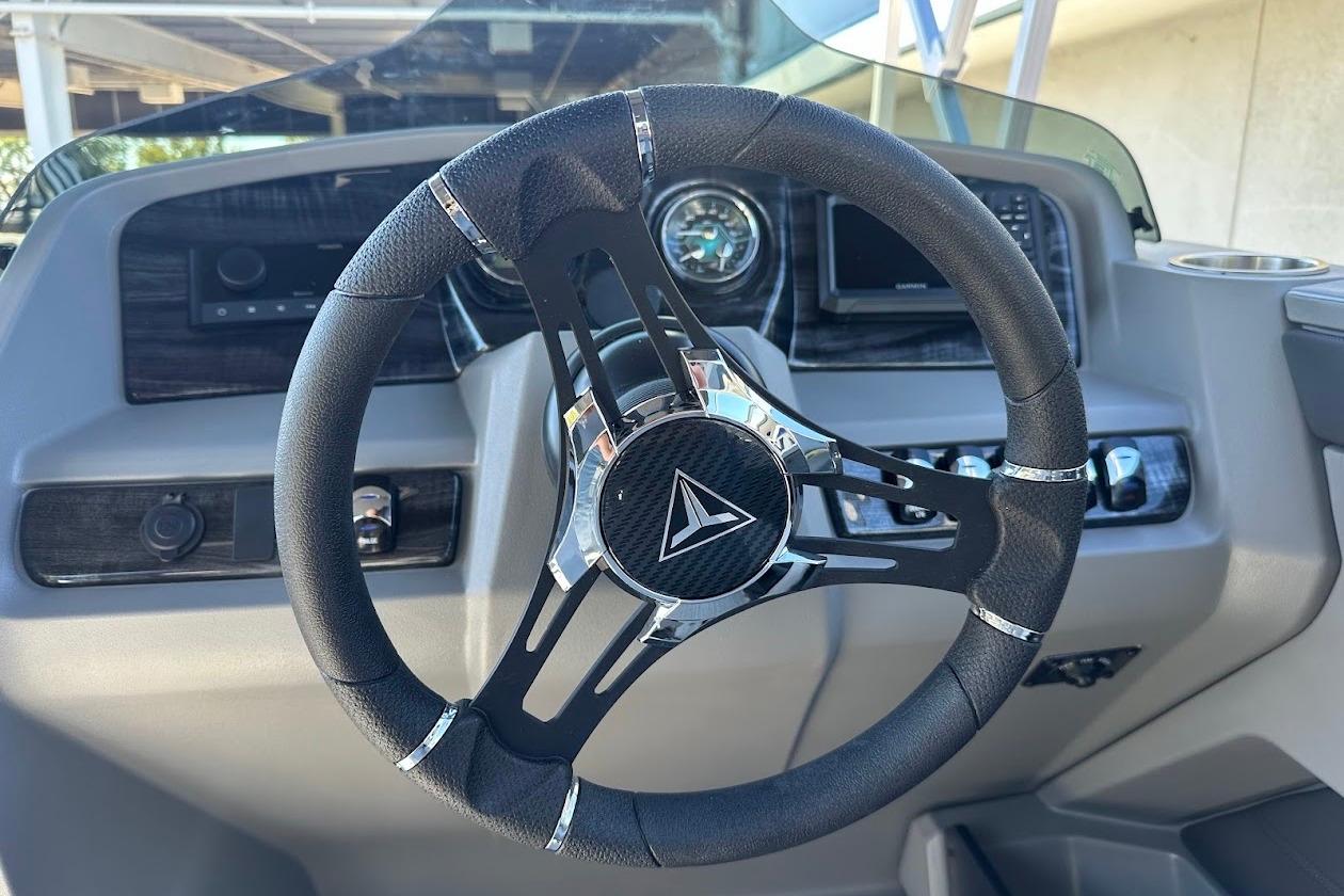 Steering wheel of 2026 Tahoe Pontoon LTZ Quad Lounger Shift 23, featuring modern dashboard controls.