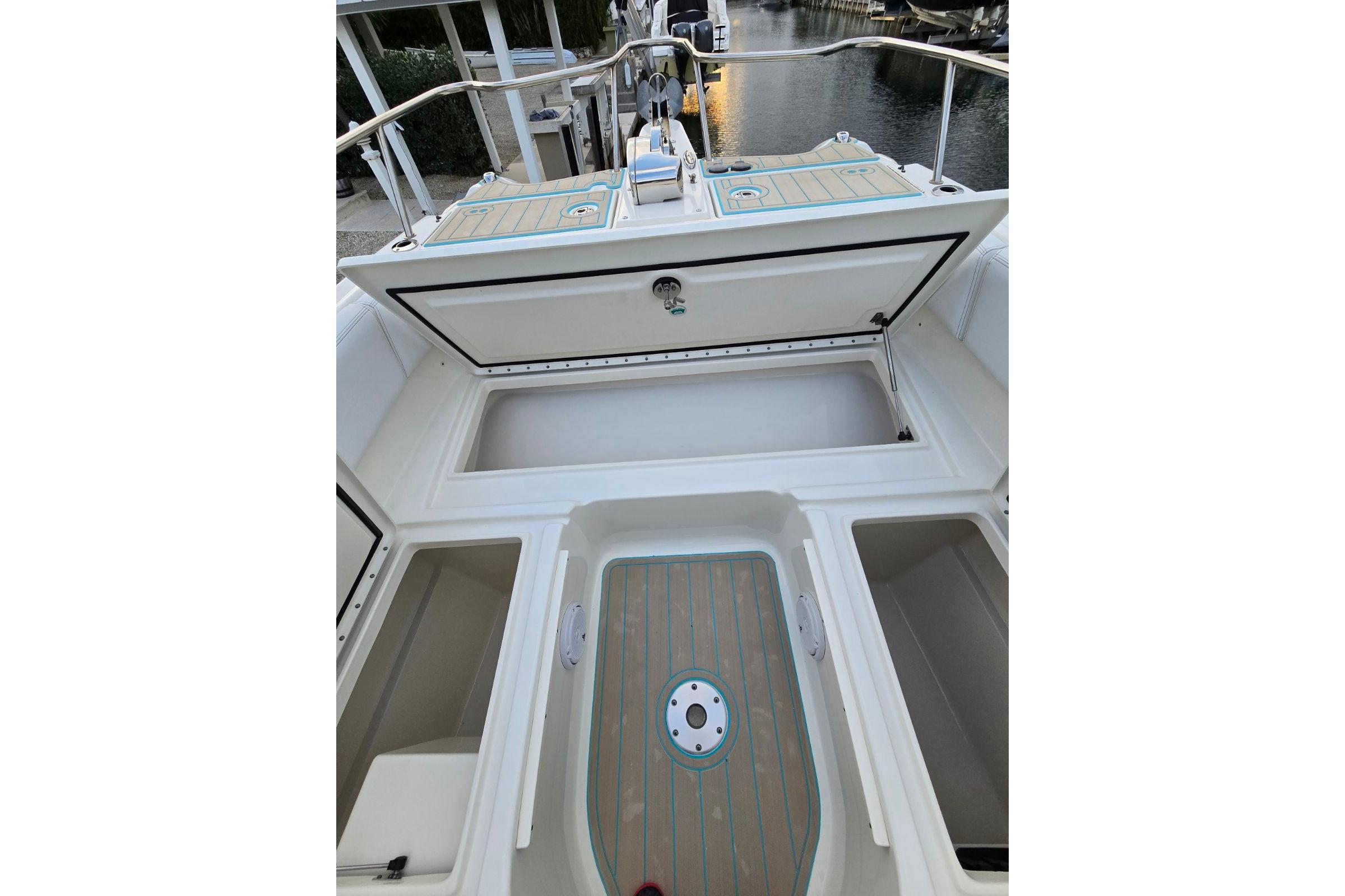 2019 World Cat 255 DC boat interior with open storage compartments and deck view.